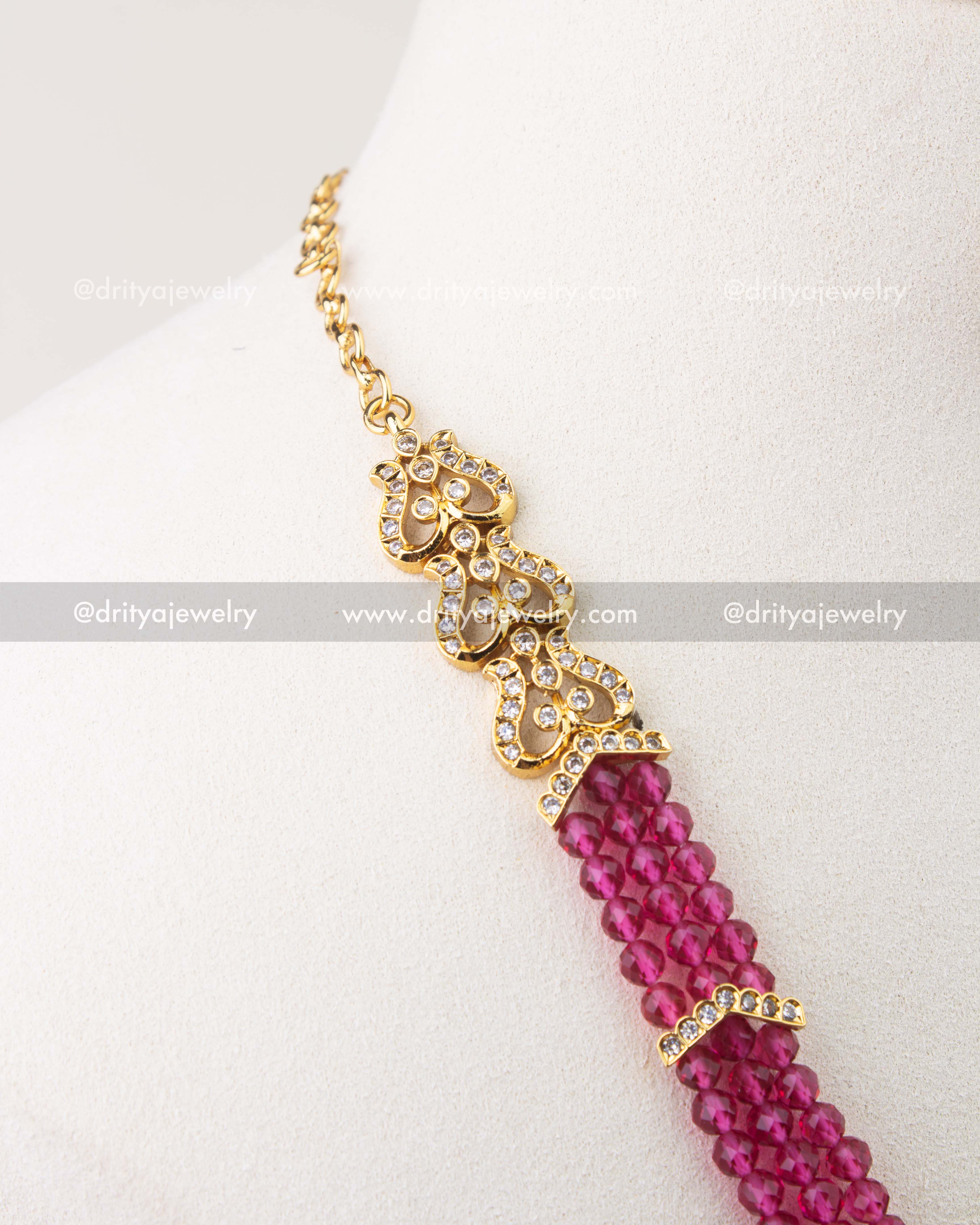 Back side detail of pink beaded necklace with gold-toned chain and stone-studded link.