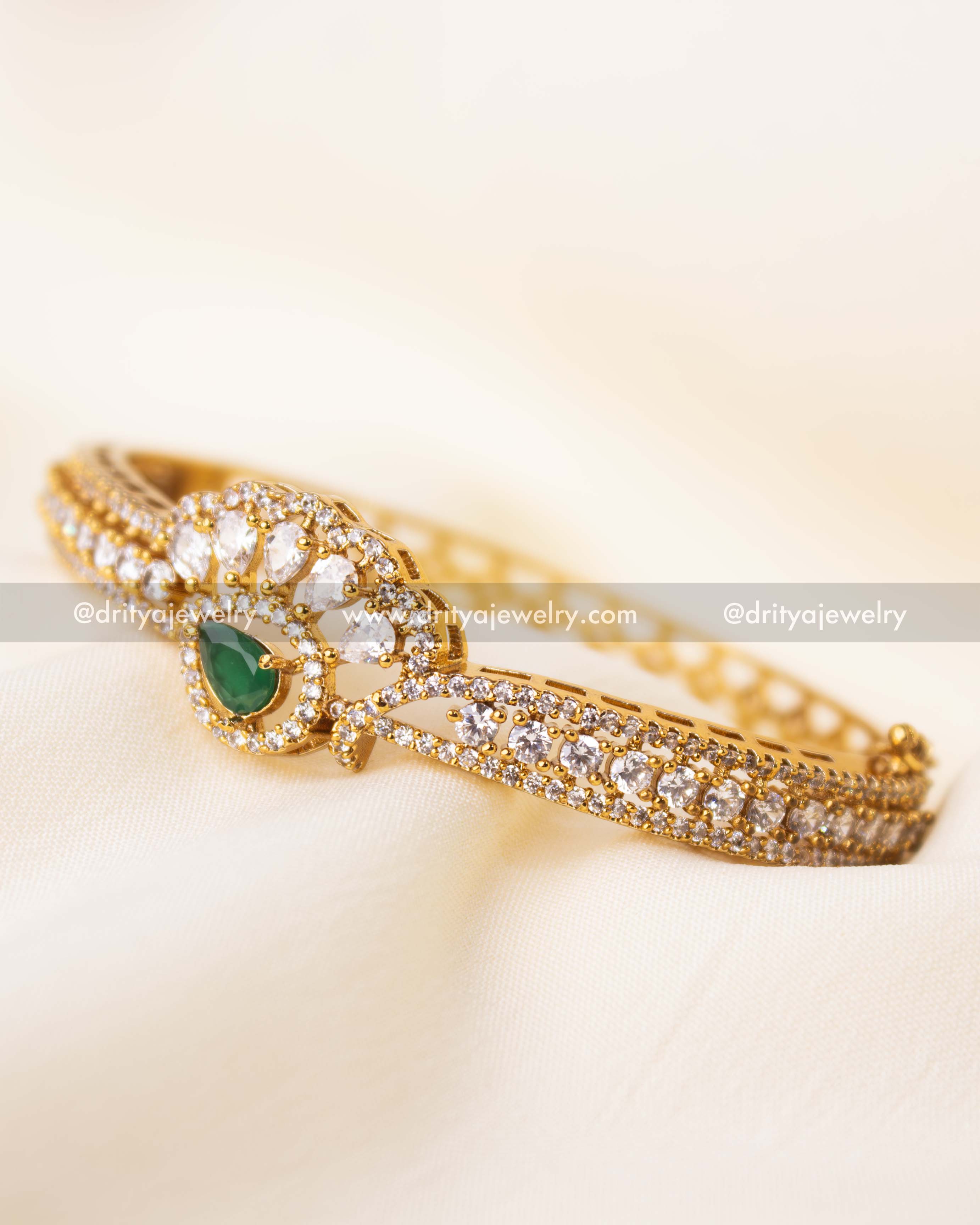 Elegant adjustable kada with emerald green teardrop stone and CZ embellishments.