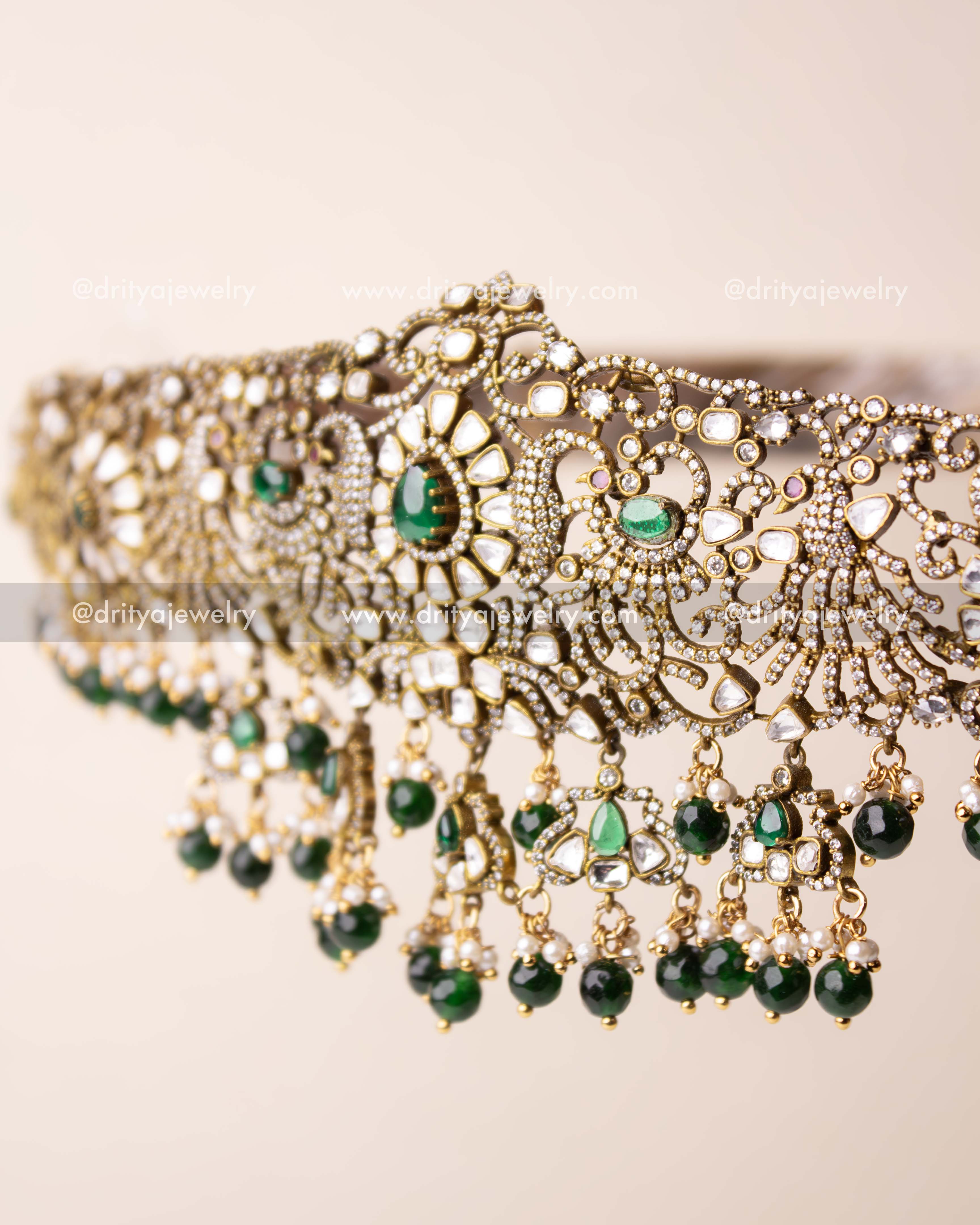 Side-angle of waist belt showing green drops and intricate kundan work.