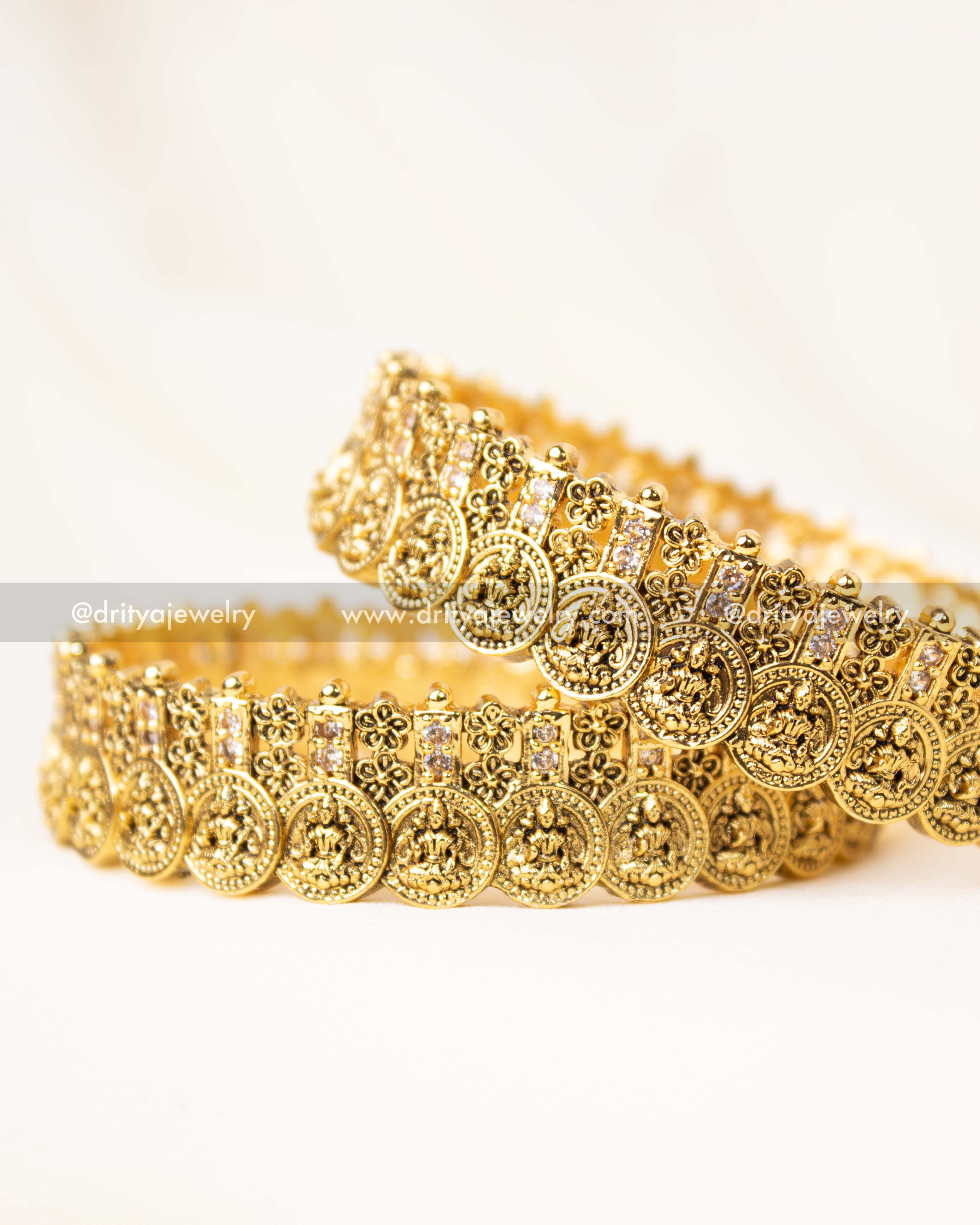 Traditional gold-plated Nakshi bangle set featuring Lakshmi coin motifs and floral engravings.