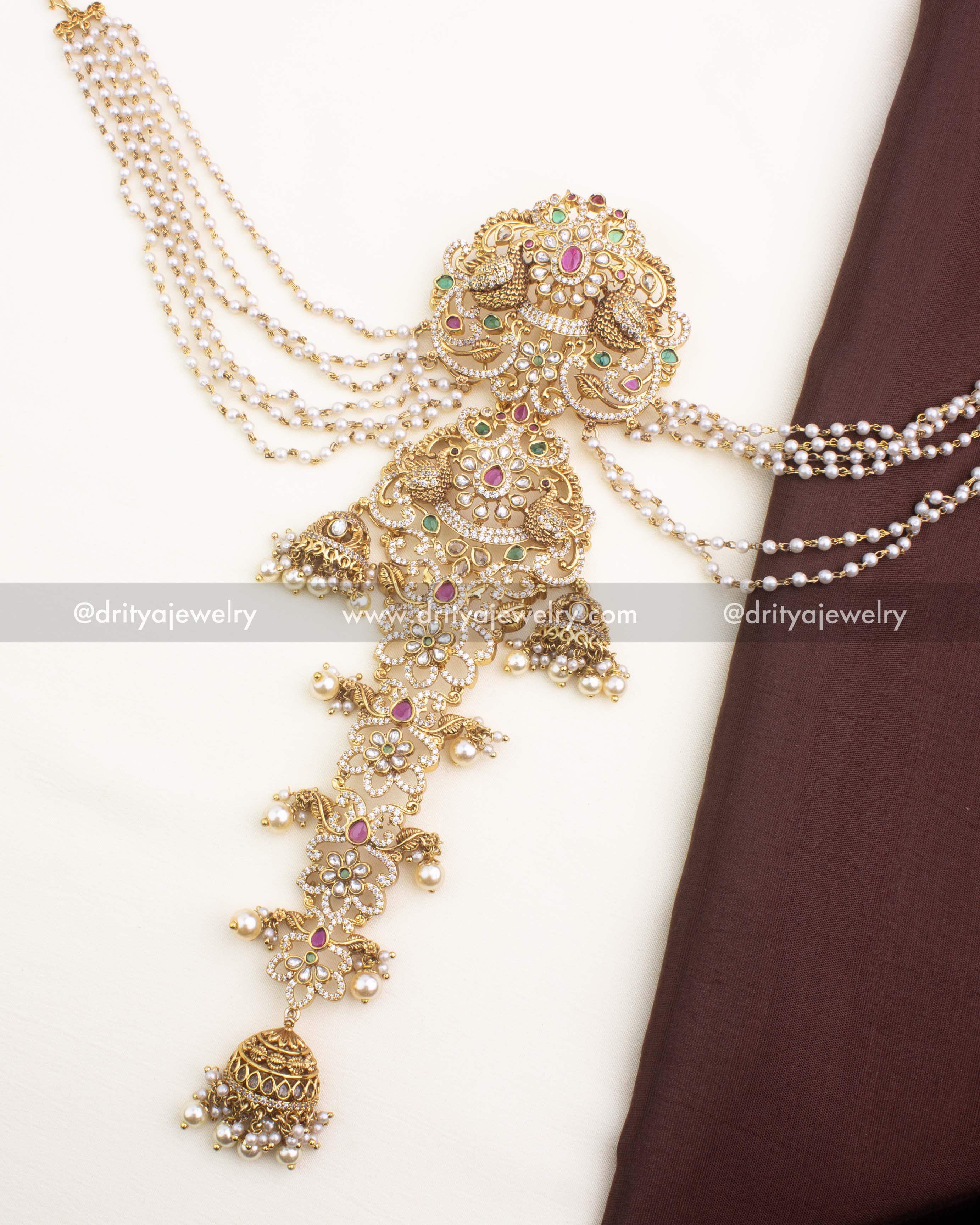 Mid-length antique jada billa featuring floral-peacock designs and layered pearl champaswaralu strands.
