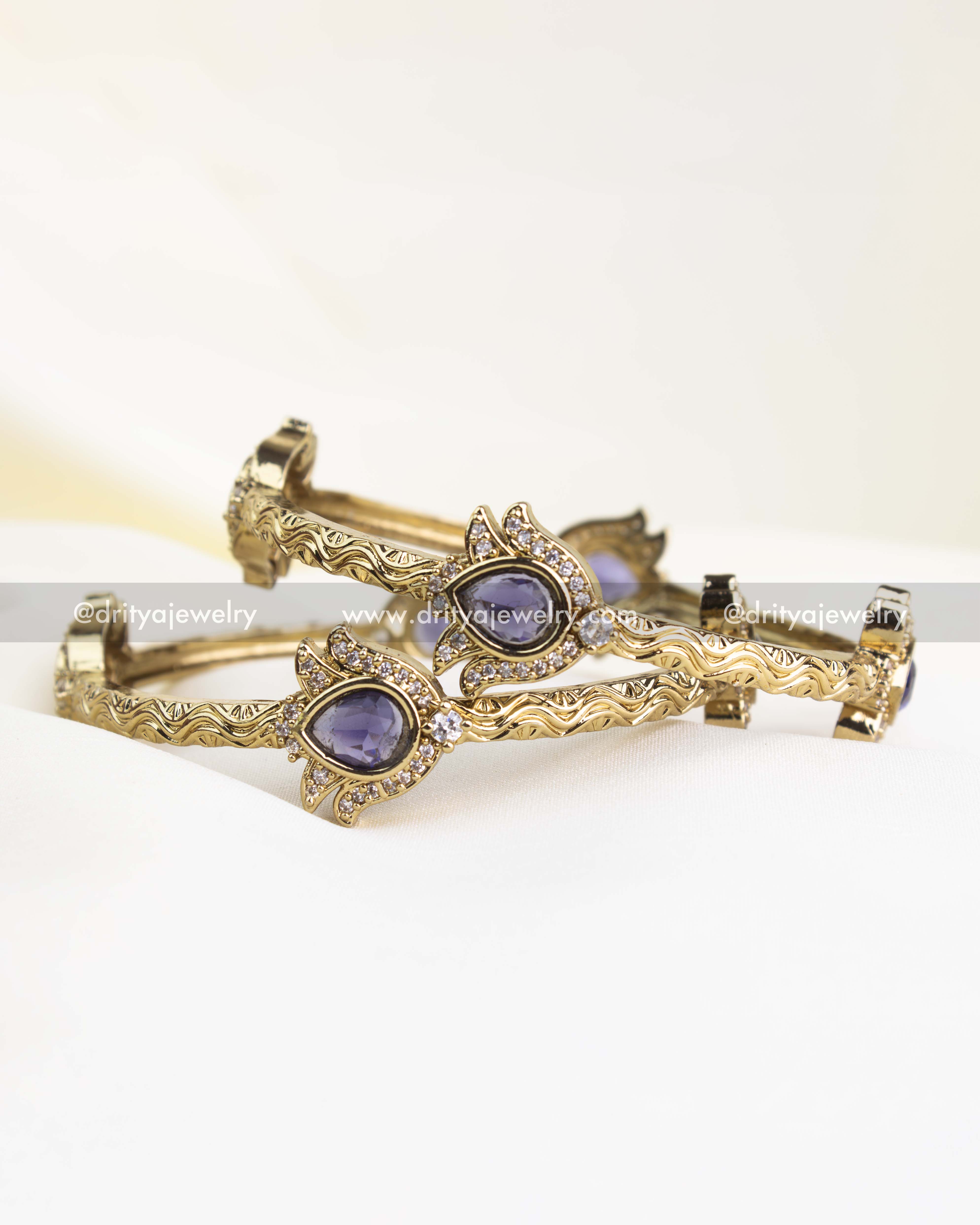 Antique gold finish kada with purple pear-cut stones and CZ border detailing.