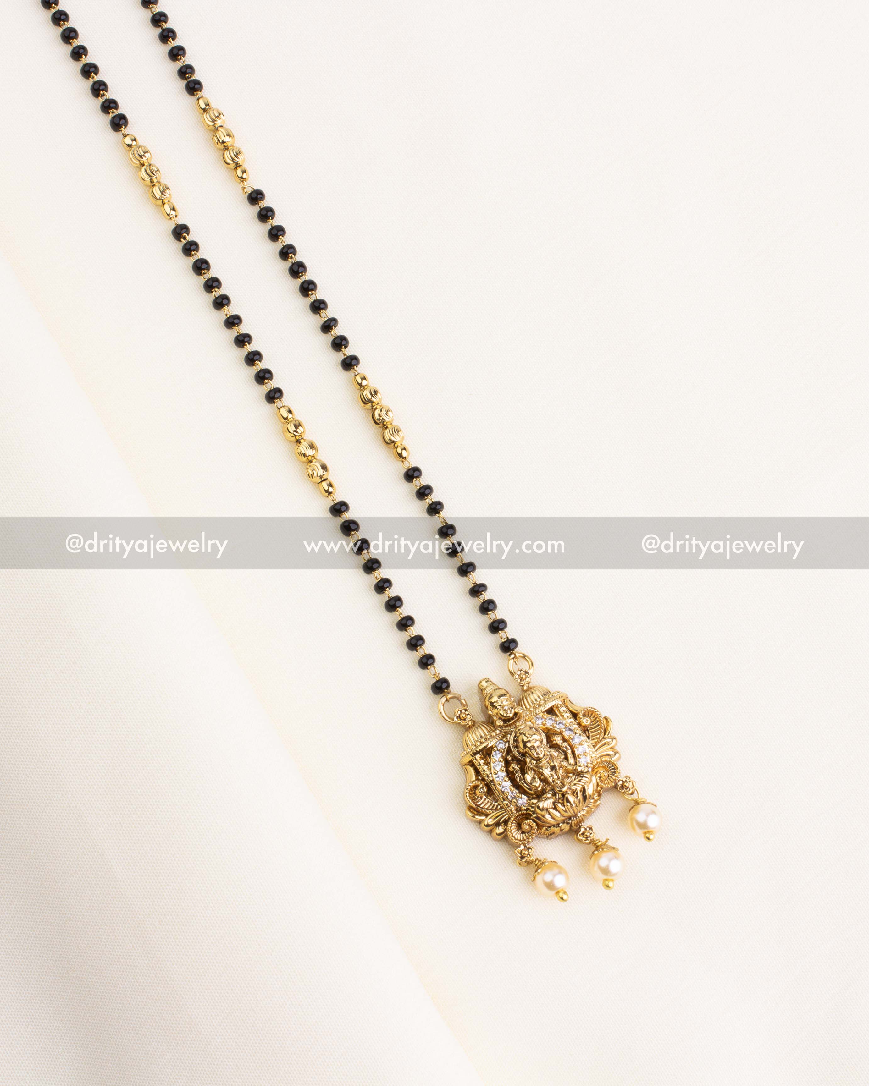 Traditional necklace with dual black bead strands and Lakshmi Devi gold pendant with pearl drops.