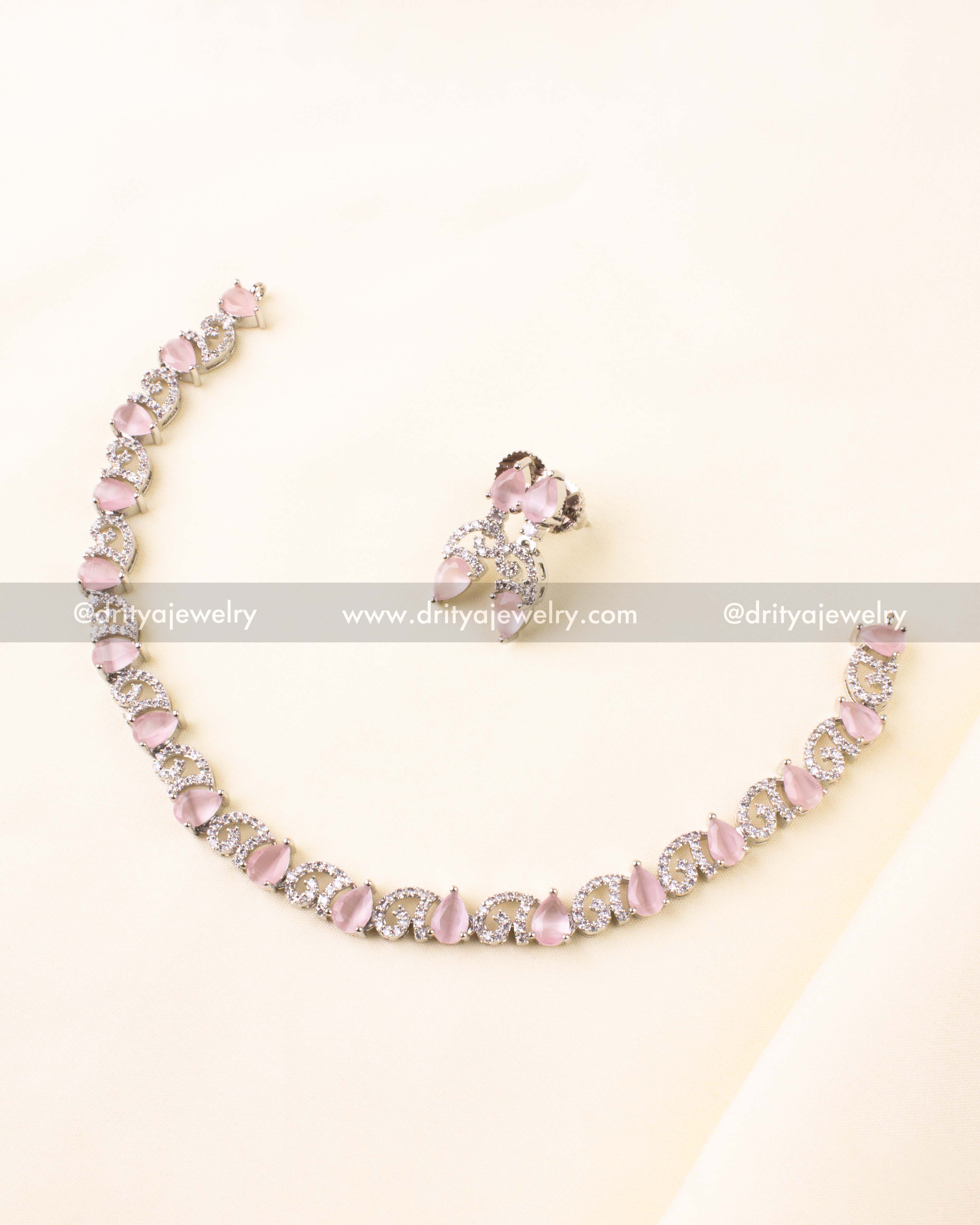 Silver-finish necklace set with blush pink pear-shaped stones and shimmering CZ swirls.