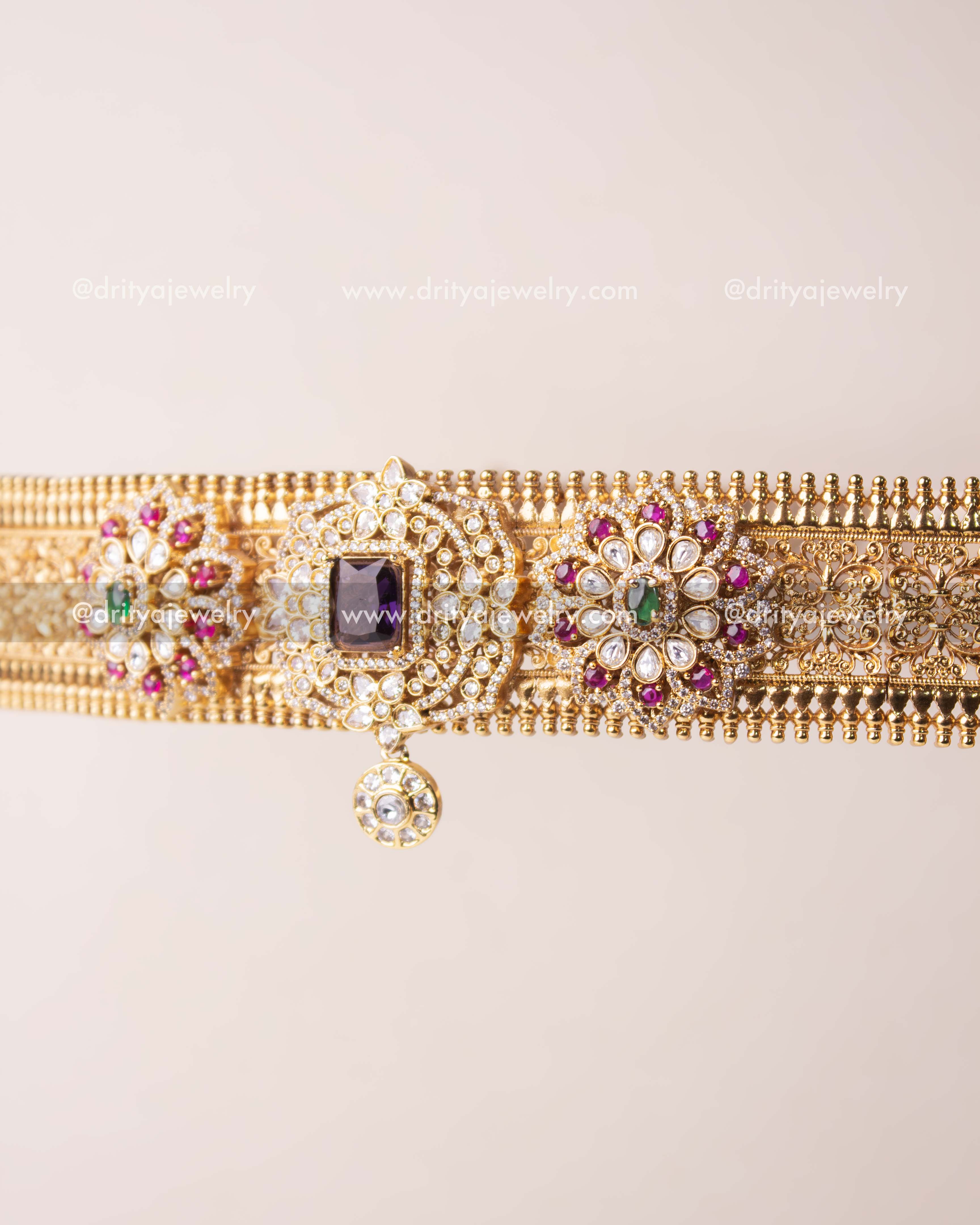 Detailed close-up of square AD centerpiece with surrounding circular patterns and suspended charm.