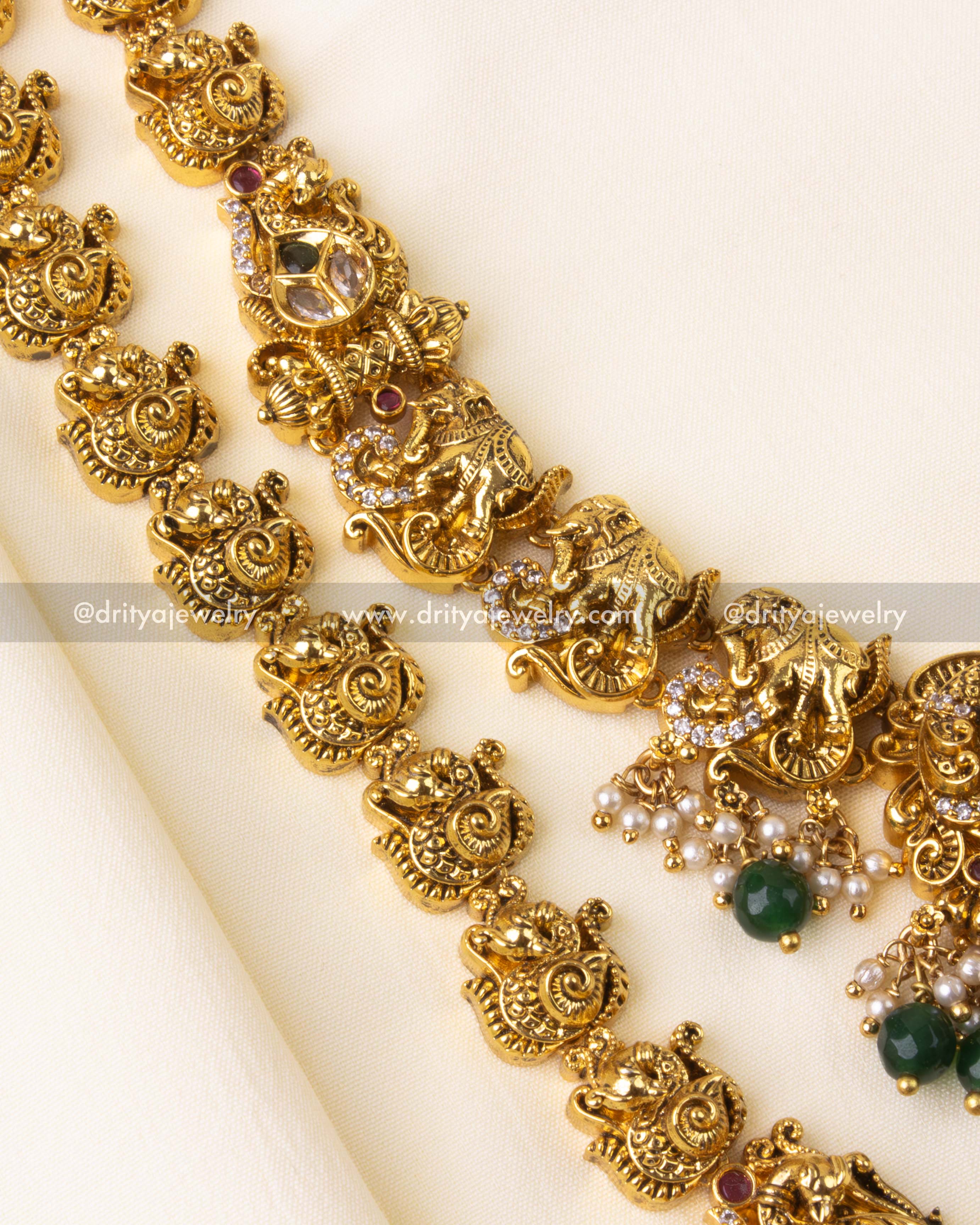 Close-up of long bridal necklace with alternating elephant and peacock temple motifs.