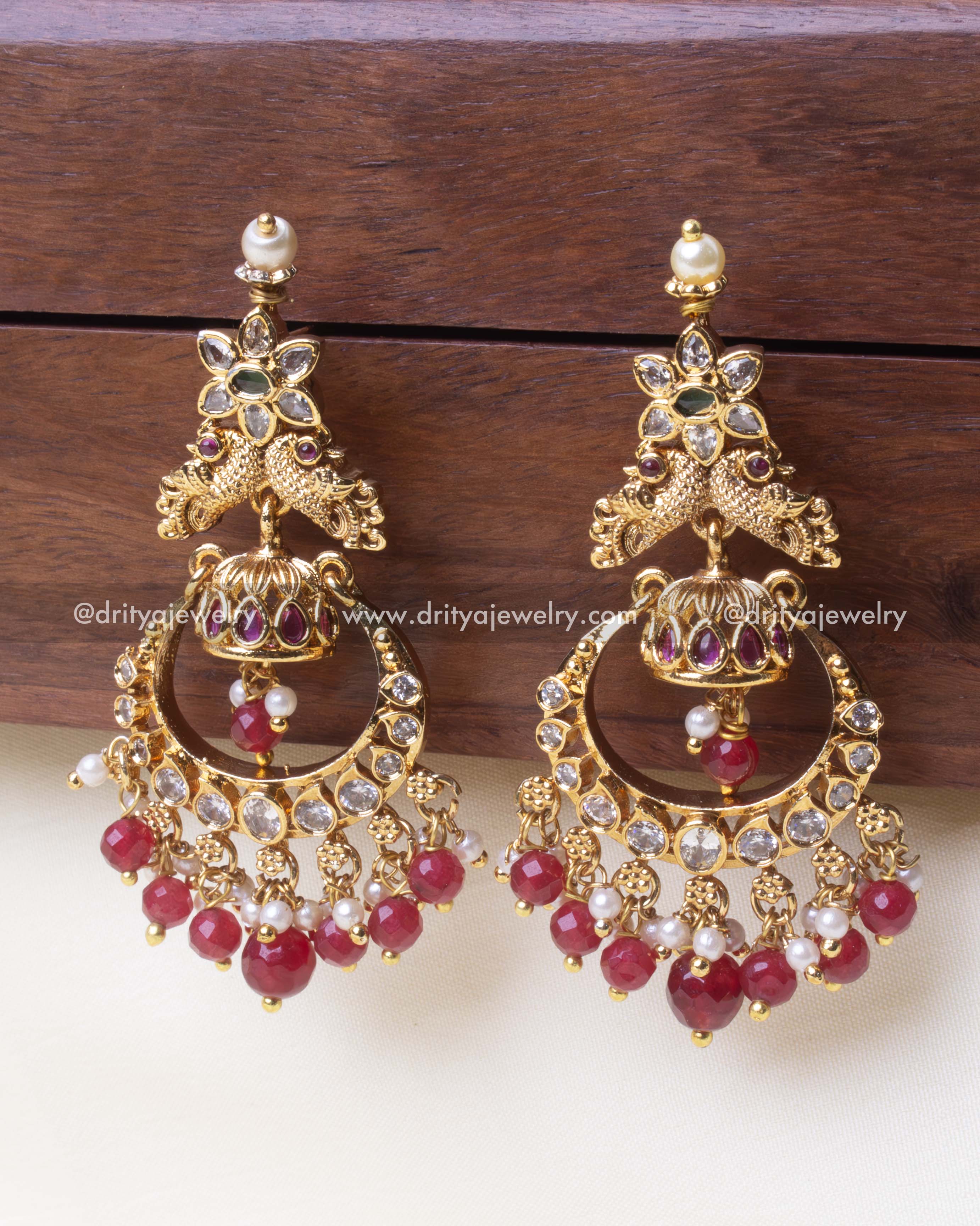 Regal gold Chandbali earring adorned with a peacock motif, ruby beads, and intricate detailing.