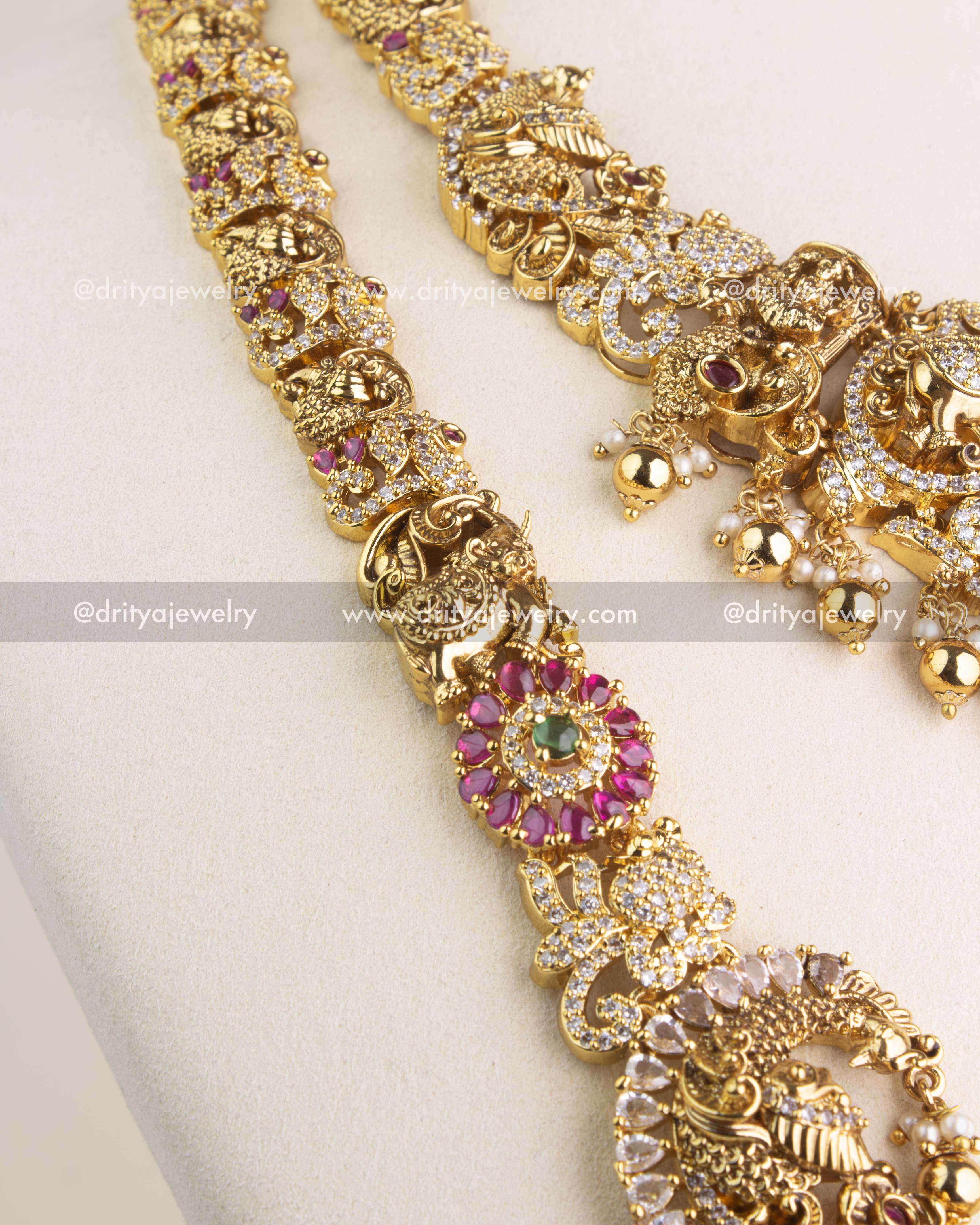 Antique gold Nakshi chain featuring intricate carvings and ruby red kemp stones.