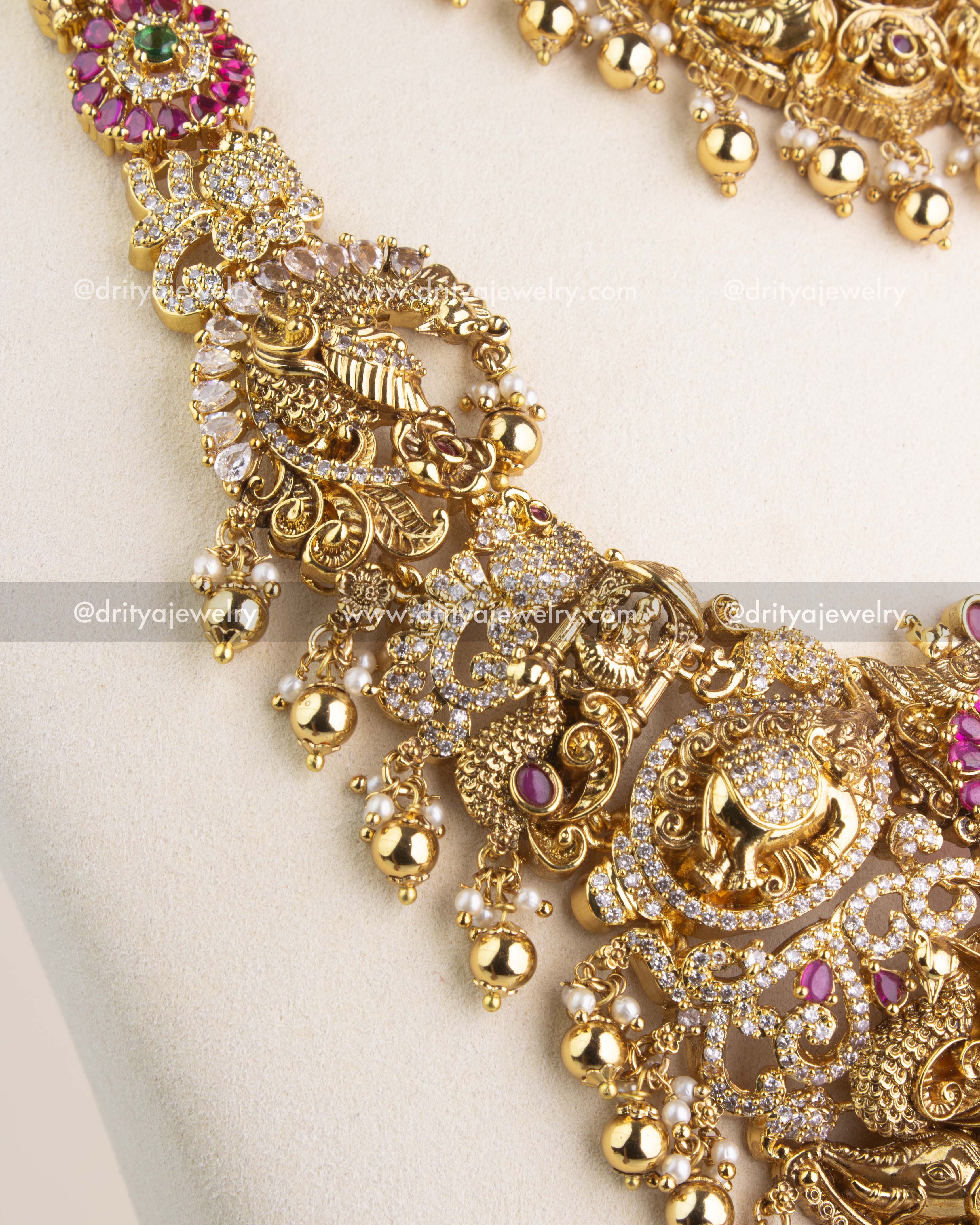 Antique gold Nakshi chain featuring intricate carvings and ruby red kemp stones.