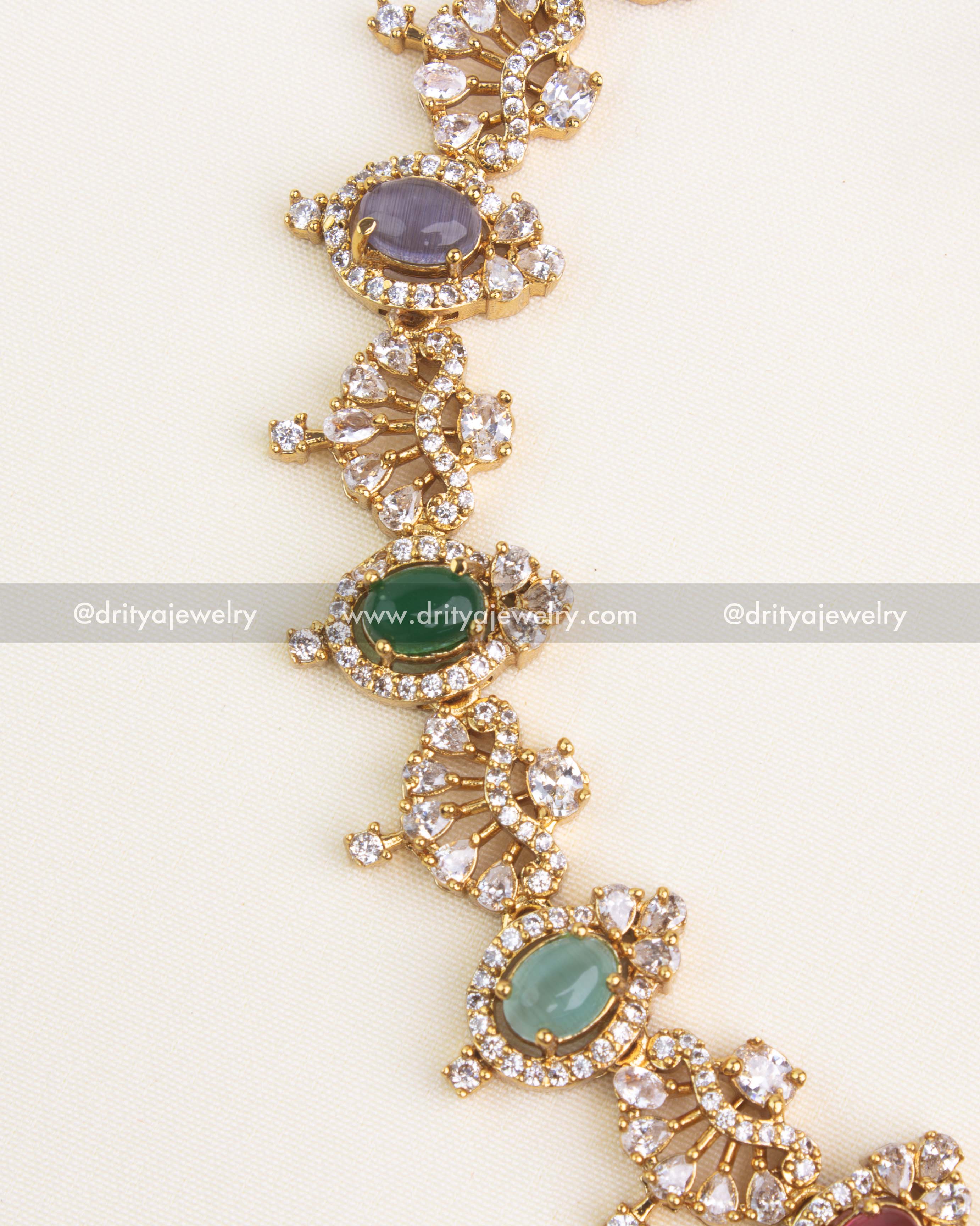 Detailed view showing oval multicolor cabochons, pear-shaped CZ fans, and pavé halo setting on a gold short necklace.