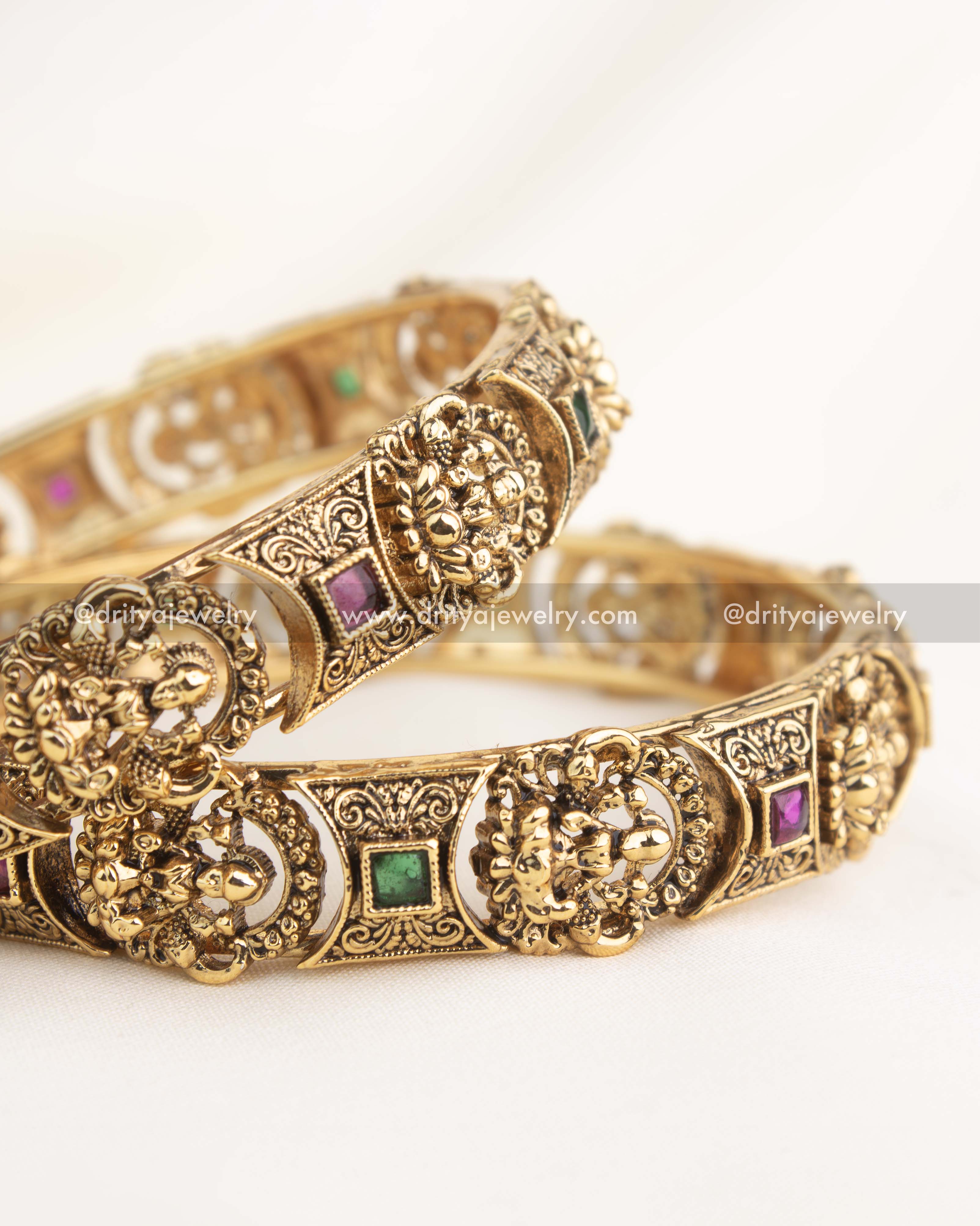 Close-up showing fine nakshi handwork with deity motifs and square ruby–emerald stones in antique finish.