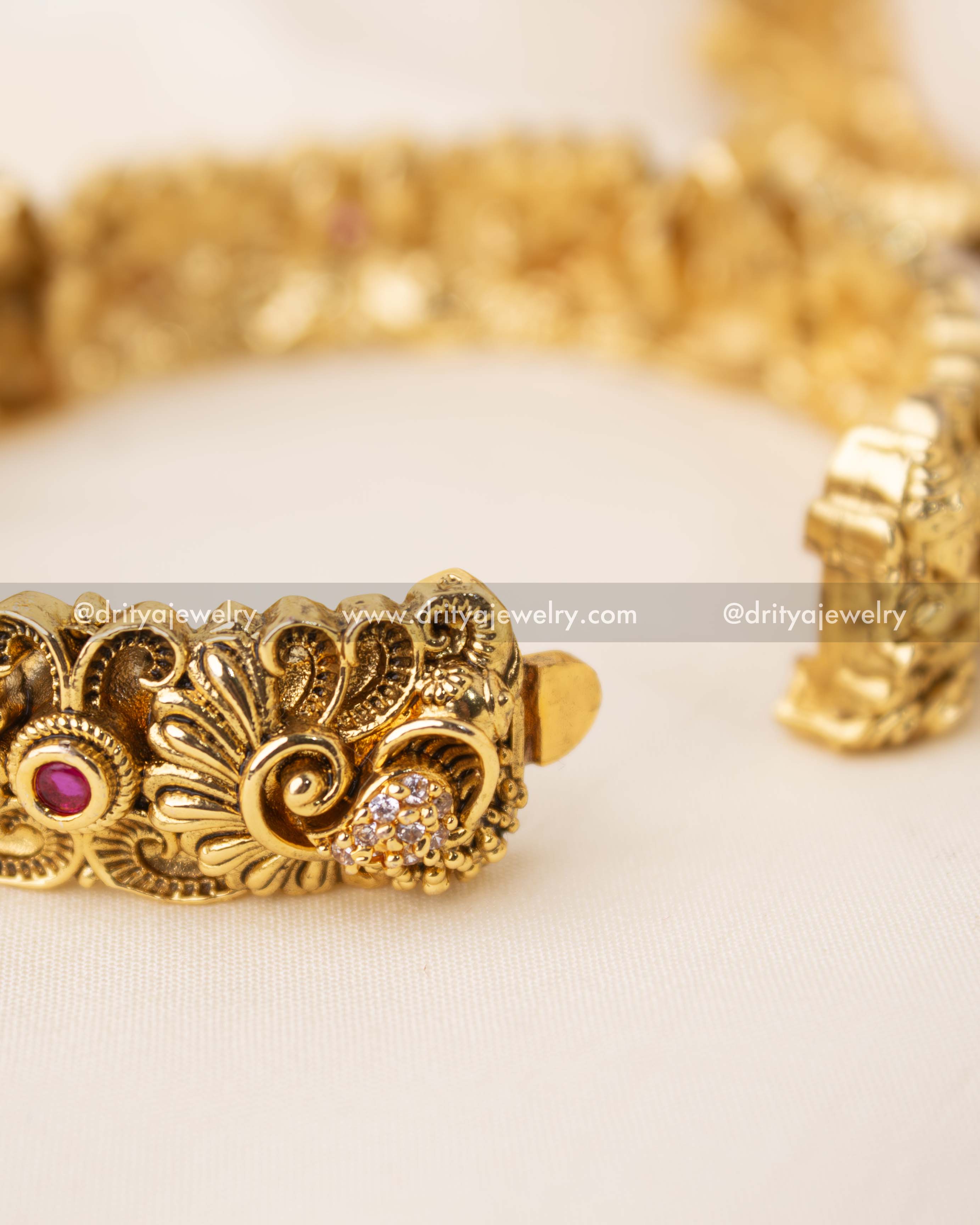 Detailed close-up of Nakshi bangle clasp with CZ sparkle and floral engraving.