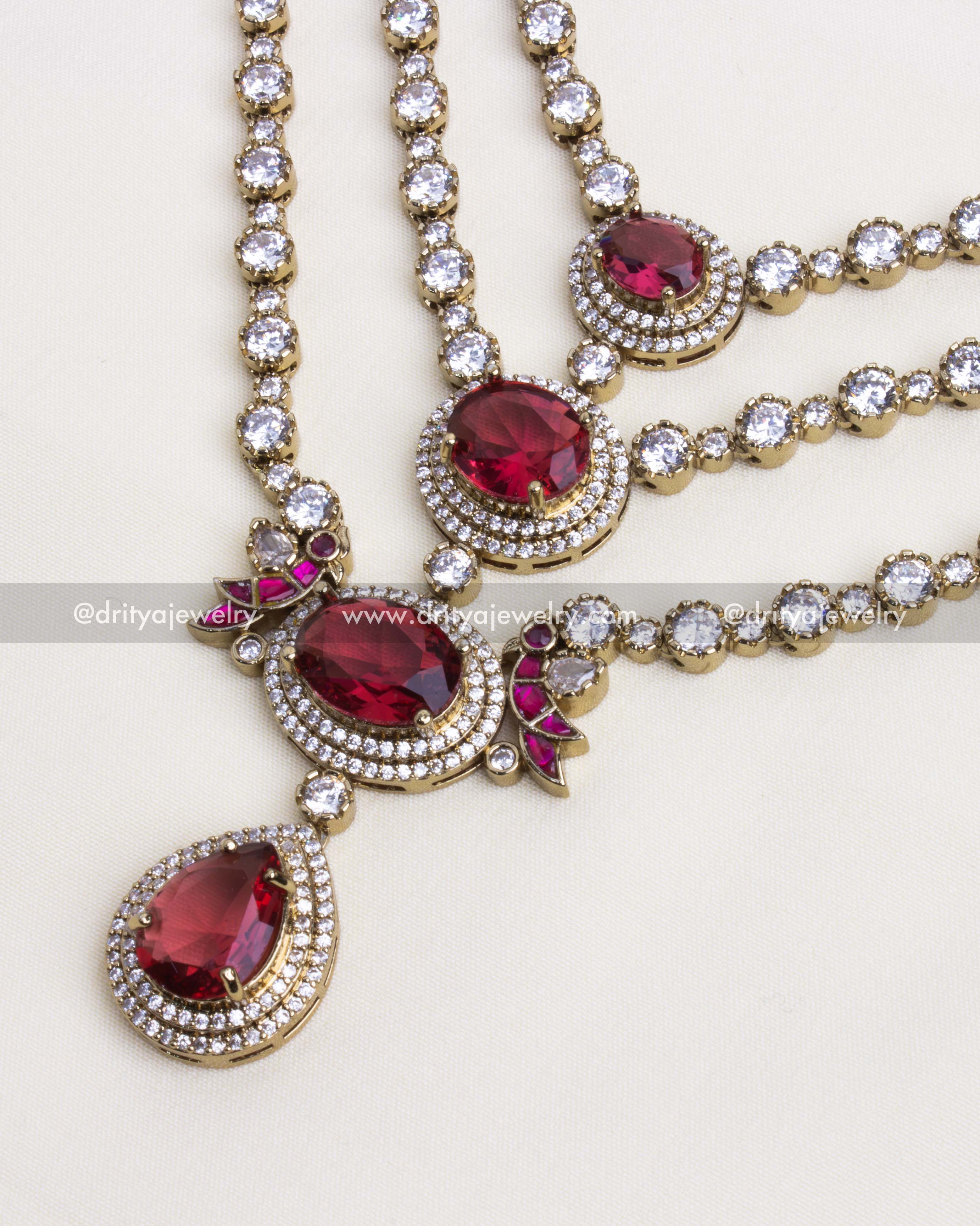 Intricate detailing of ruby accents and CZ stones in a layered necklace.