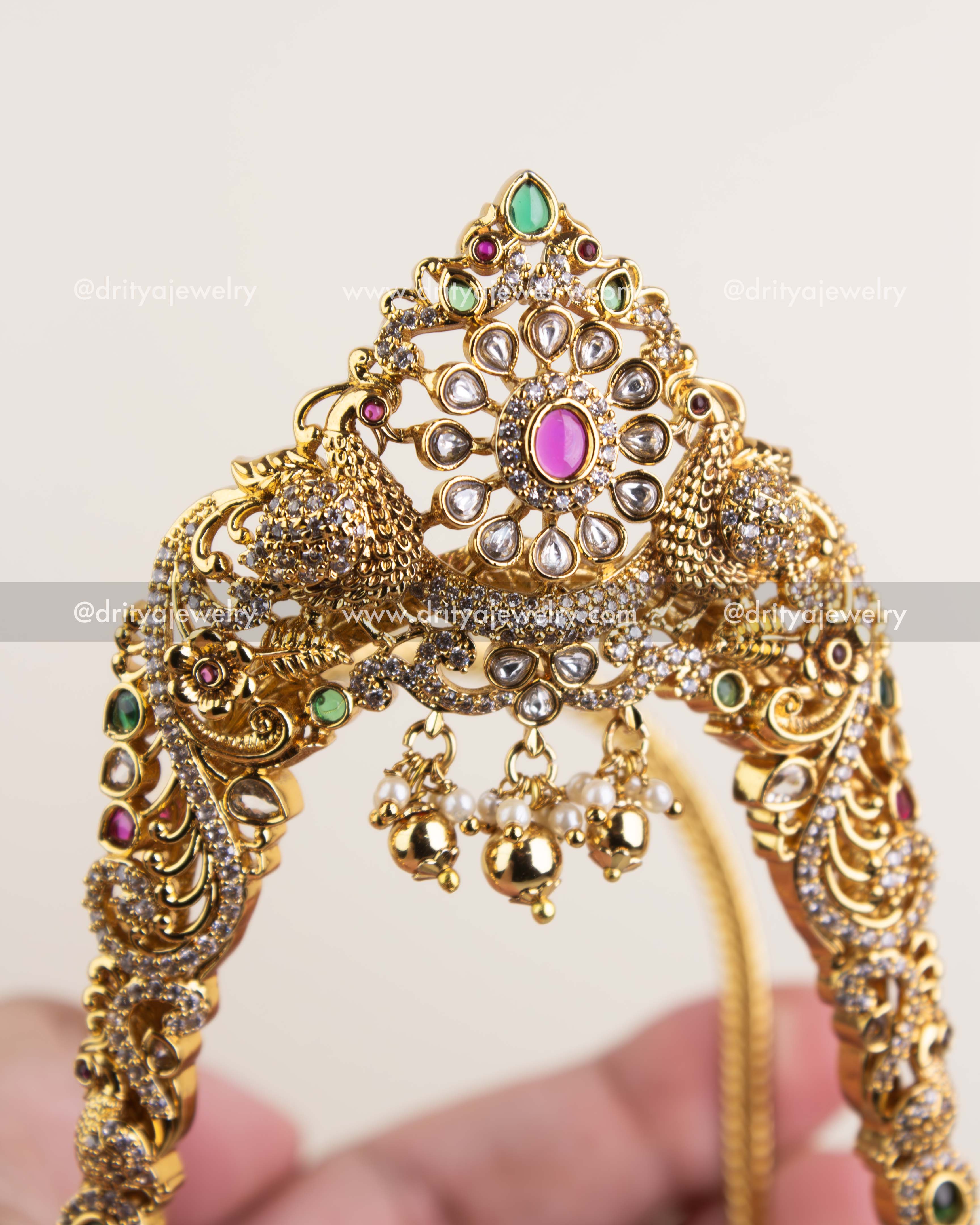 Detailed polki floral motif with ruby and emerald stones in a gold finish.