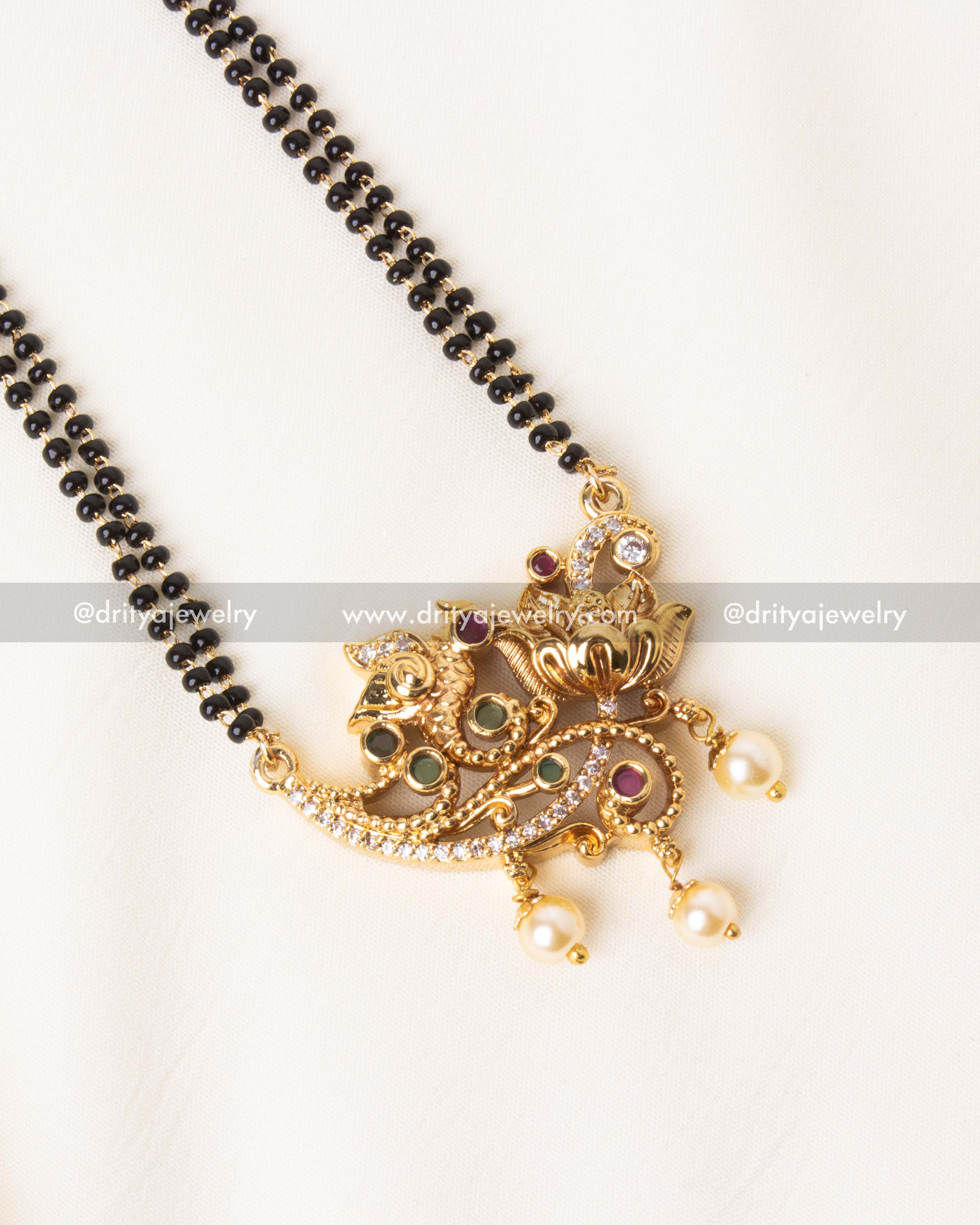 Traditional black beads mangalsutra featuring an intricately designed peacock motif pendant with pearl drops.