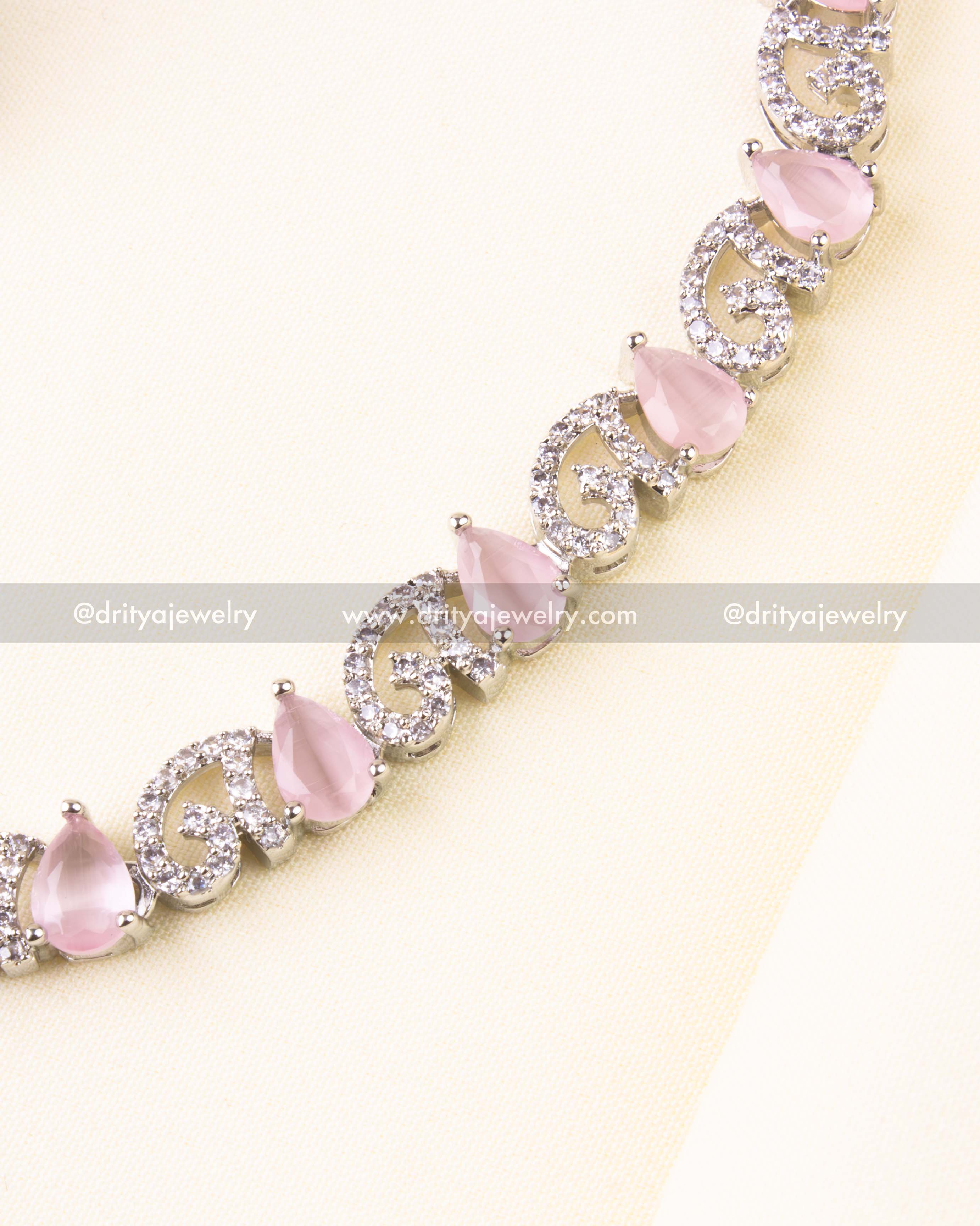 Detailed view of blush pink teardrop stones with sparkling zircon swirls on silver base.