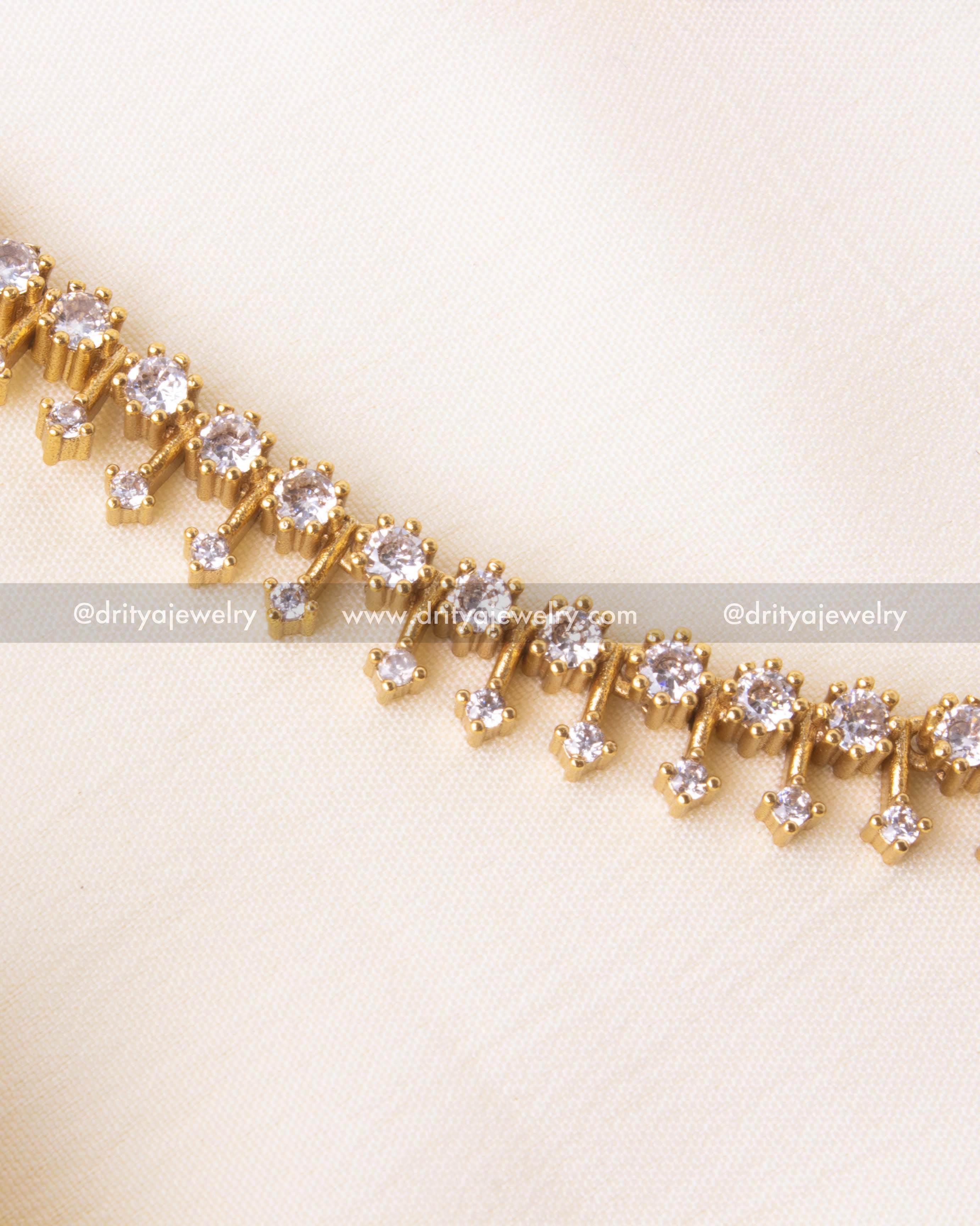 Short necklace set featuring dual-row CZ stone design with gold finish, paired with matching earrings.