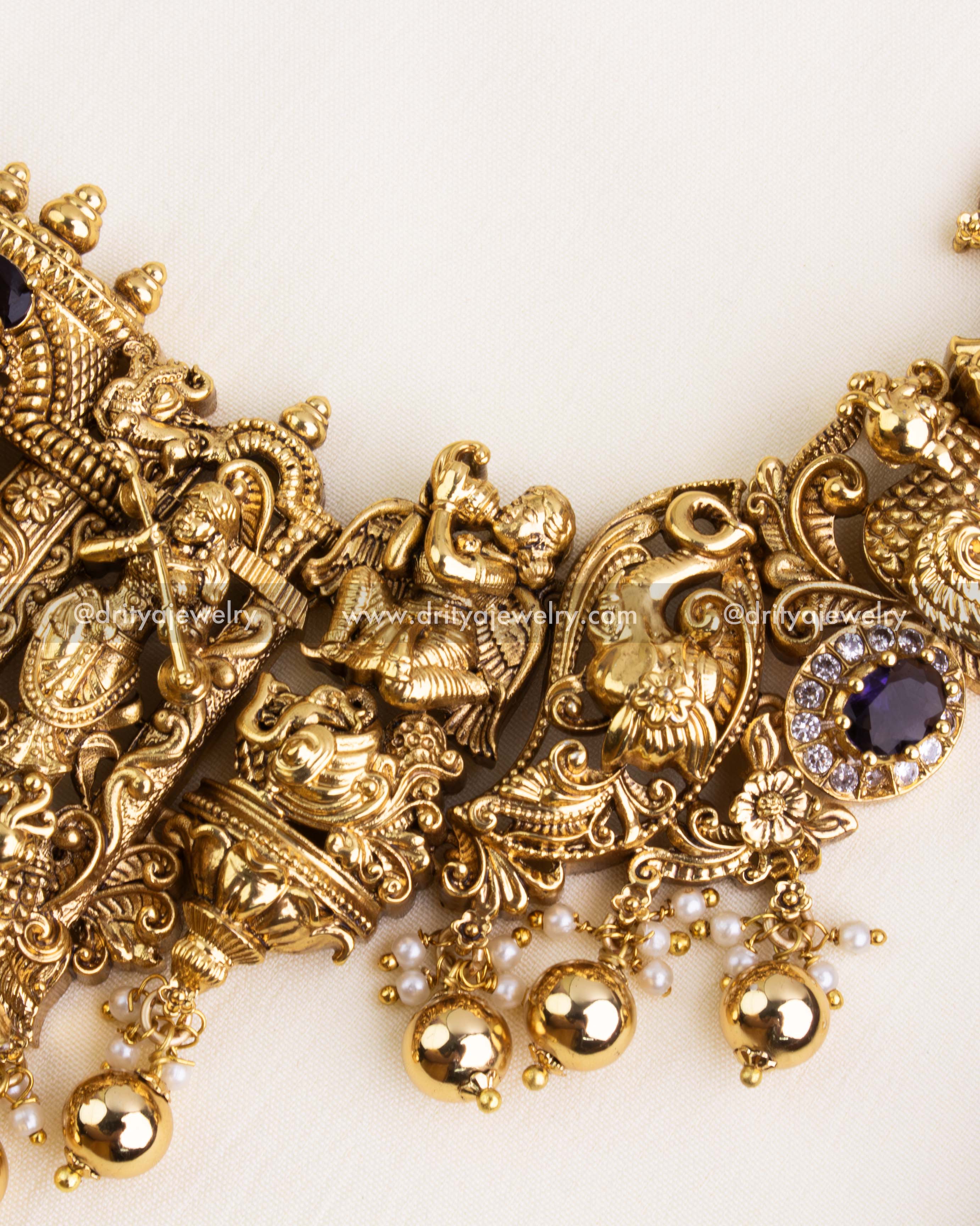 Detailed close-up of the bottom pendant featuring Lakshmi Devi, flanked by peacocks and triple-headed elephant motif in Nakshi finish with purple and white CZ stones