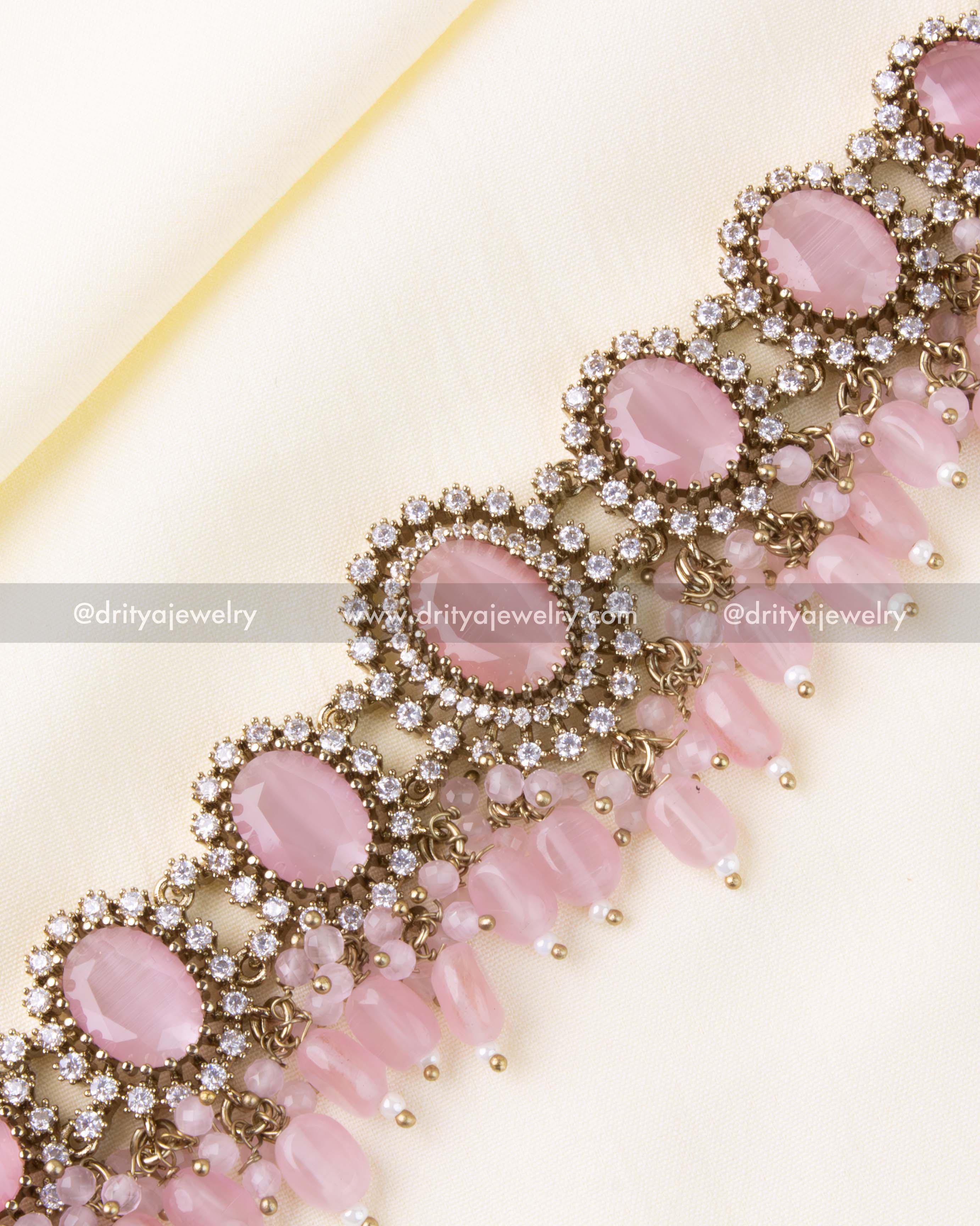 Intricate AD stone halo around blush pink center stones