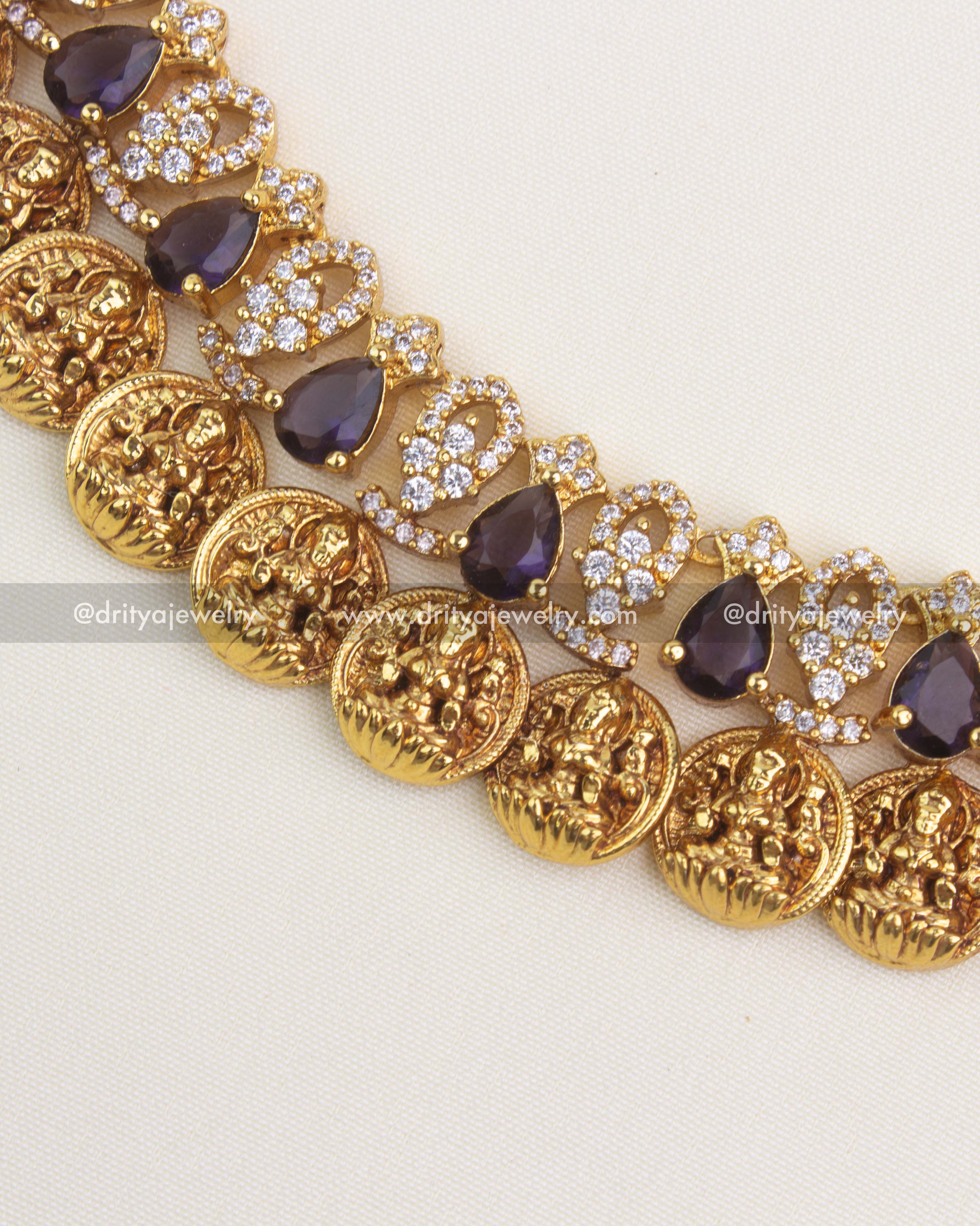 Intricate Lakshmi kasu motifs with CZ embellishments and antique gold finish.