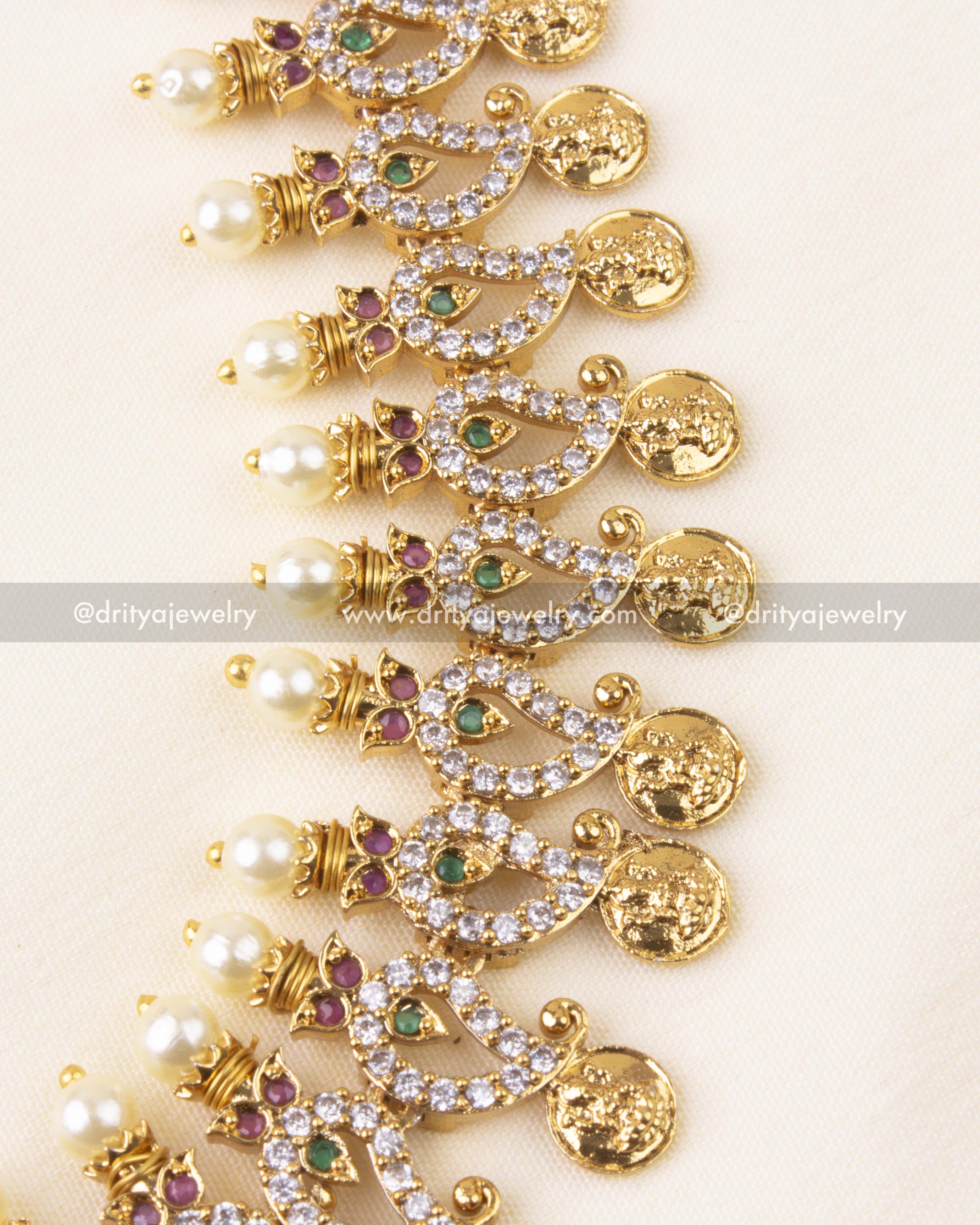 Detailed view of gold-tone kasulu coins, floral stone settings, and pearl drops.