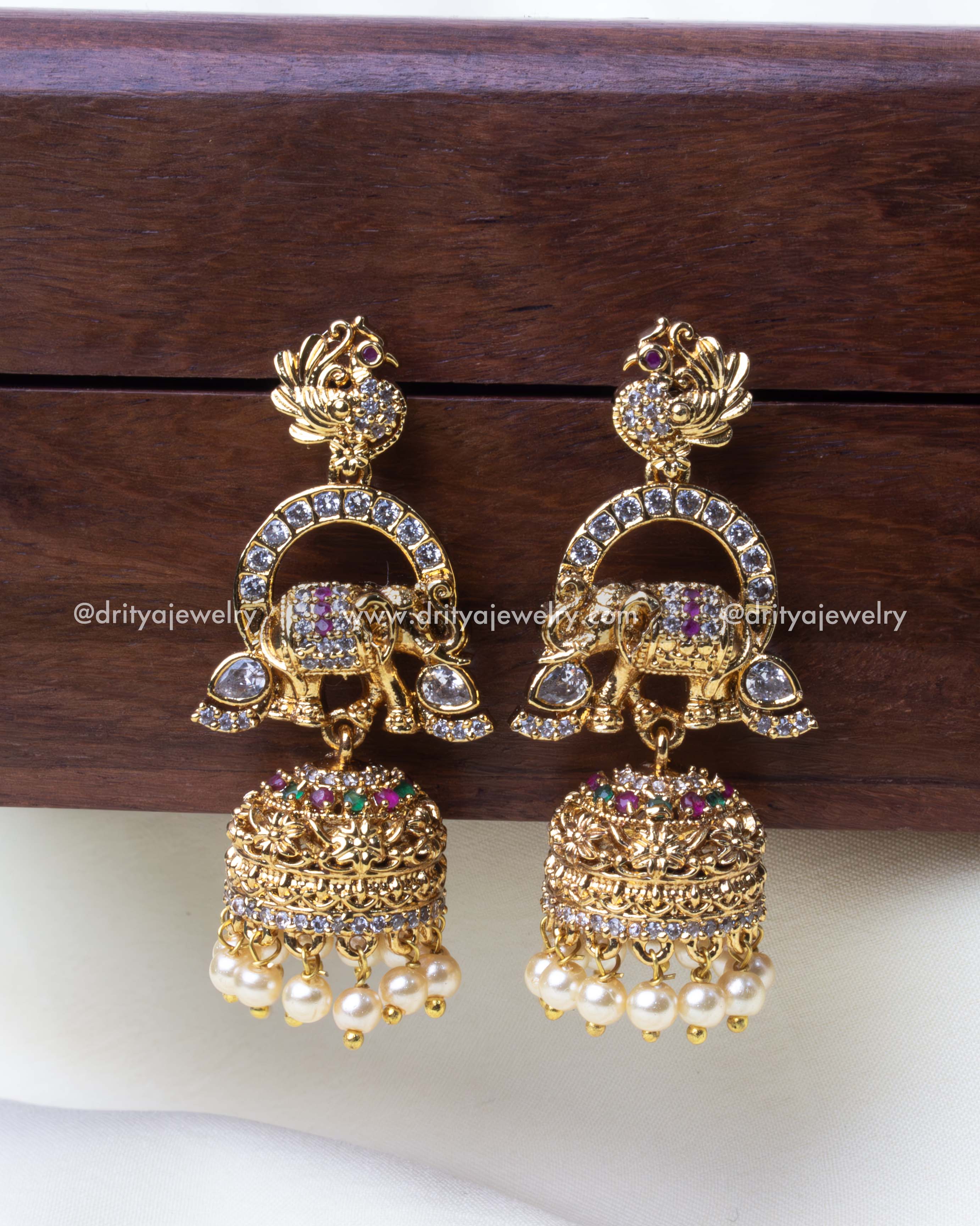 Detailed close-up of premium Jhumka earrings featuring elephant motifs and pearl hangings.