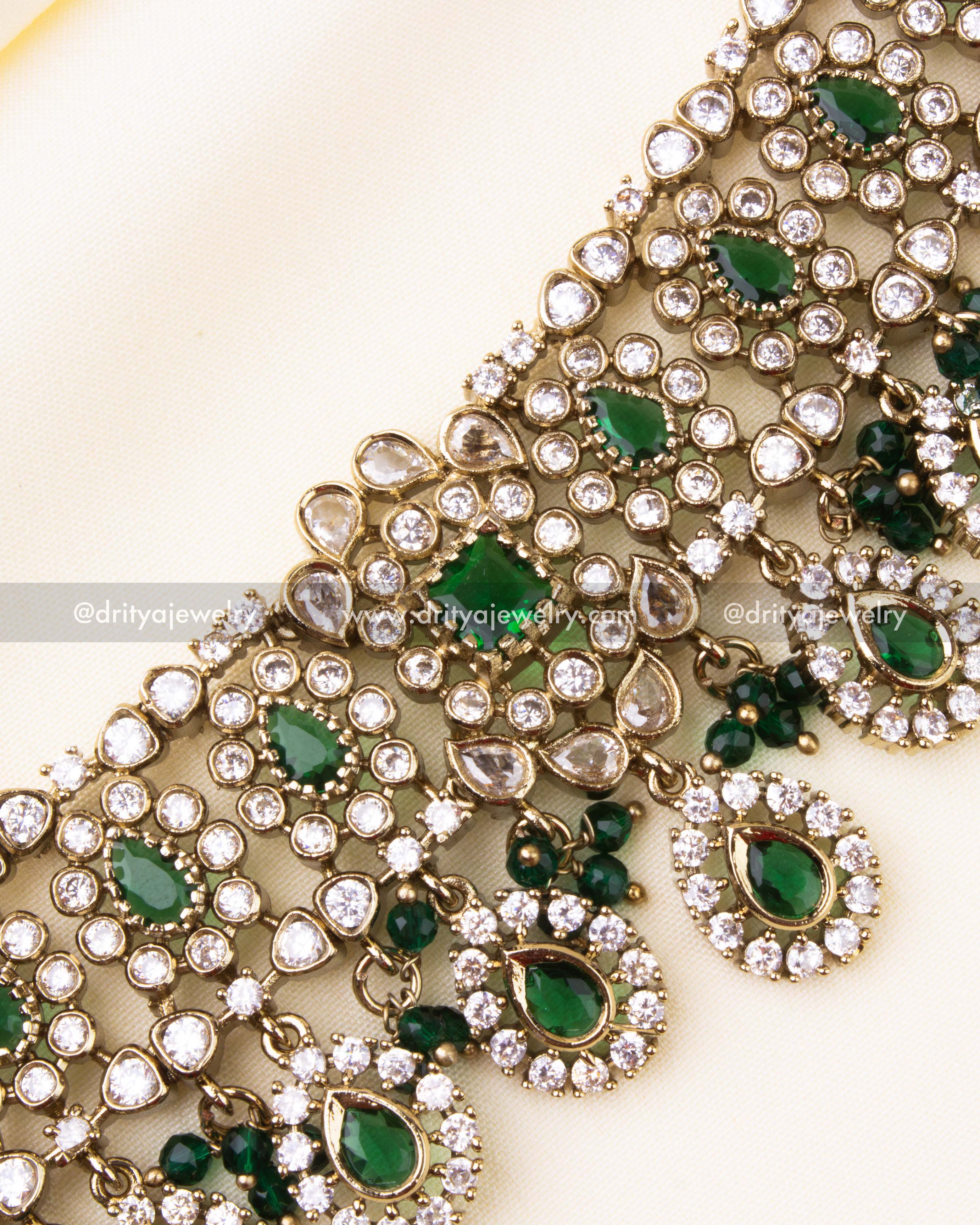 Intricate detailing of green teardrop stones and Victorian motifs with clustered beads.
