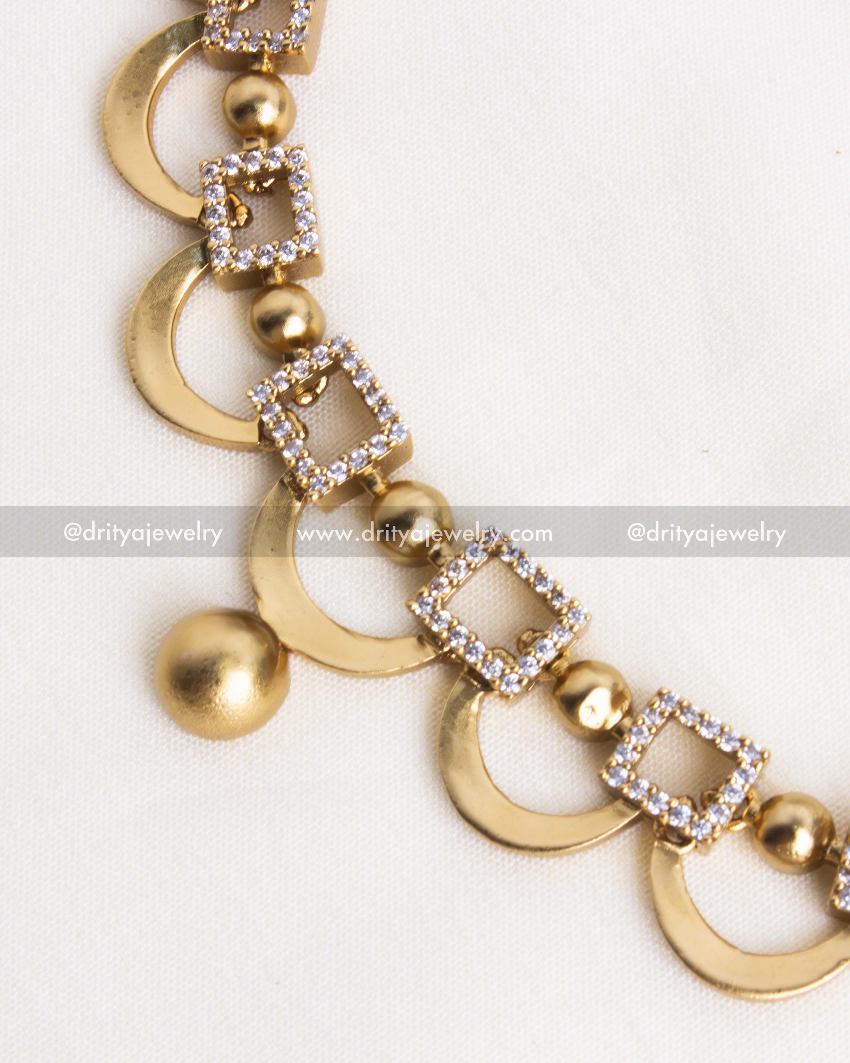 Detailed close-up of the short necklace with CZ stone embellishments and golden finish.