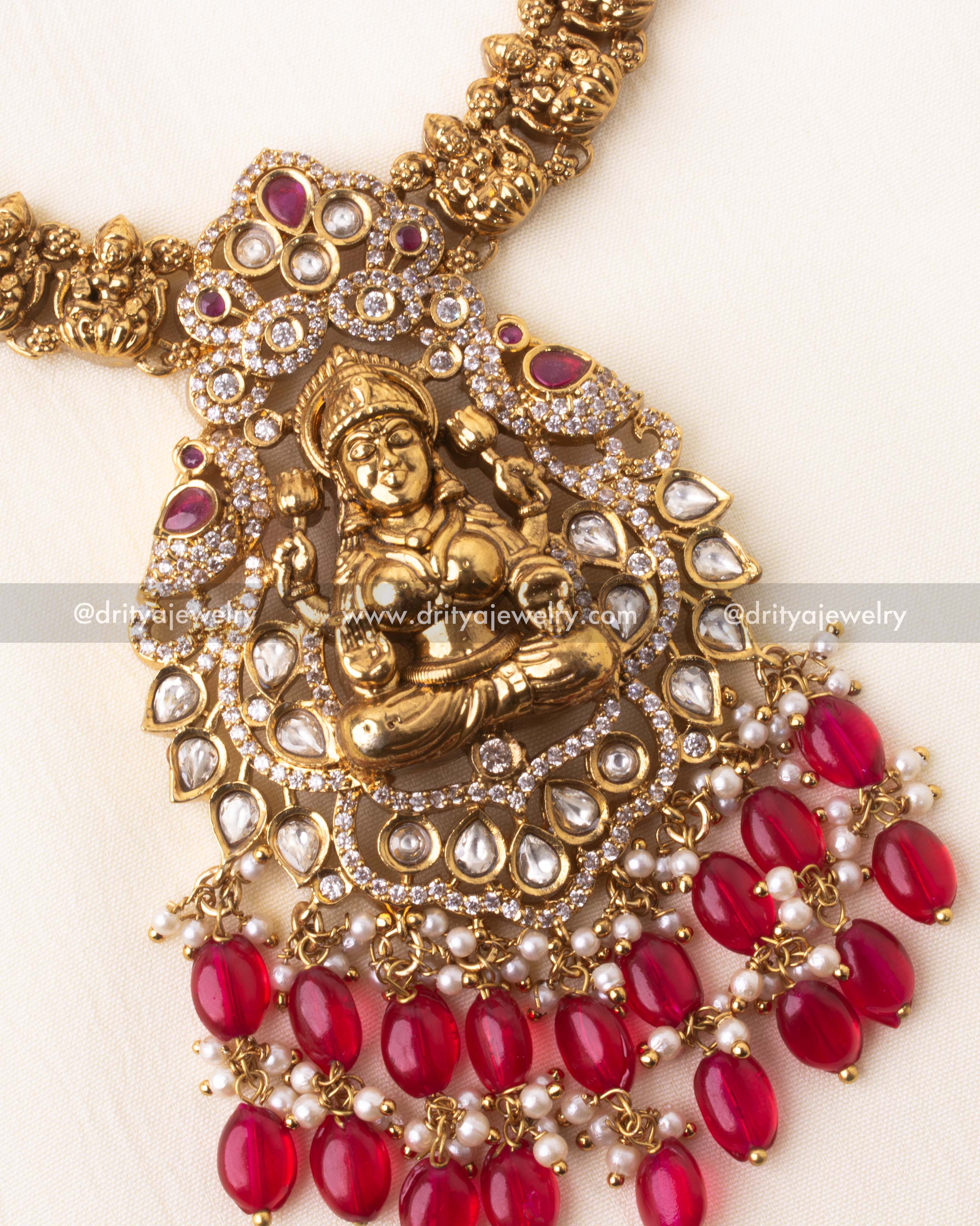 Detailed view of the Nakshi-style Lakshmi pendant surrounded by kundan stones and red beads.