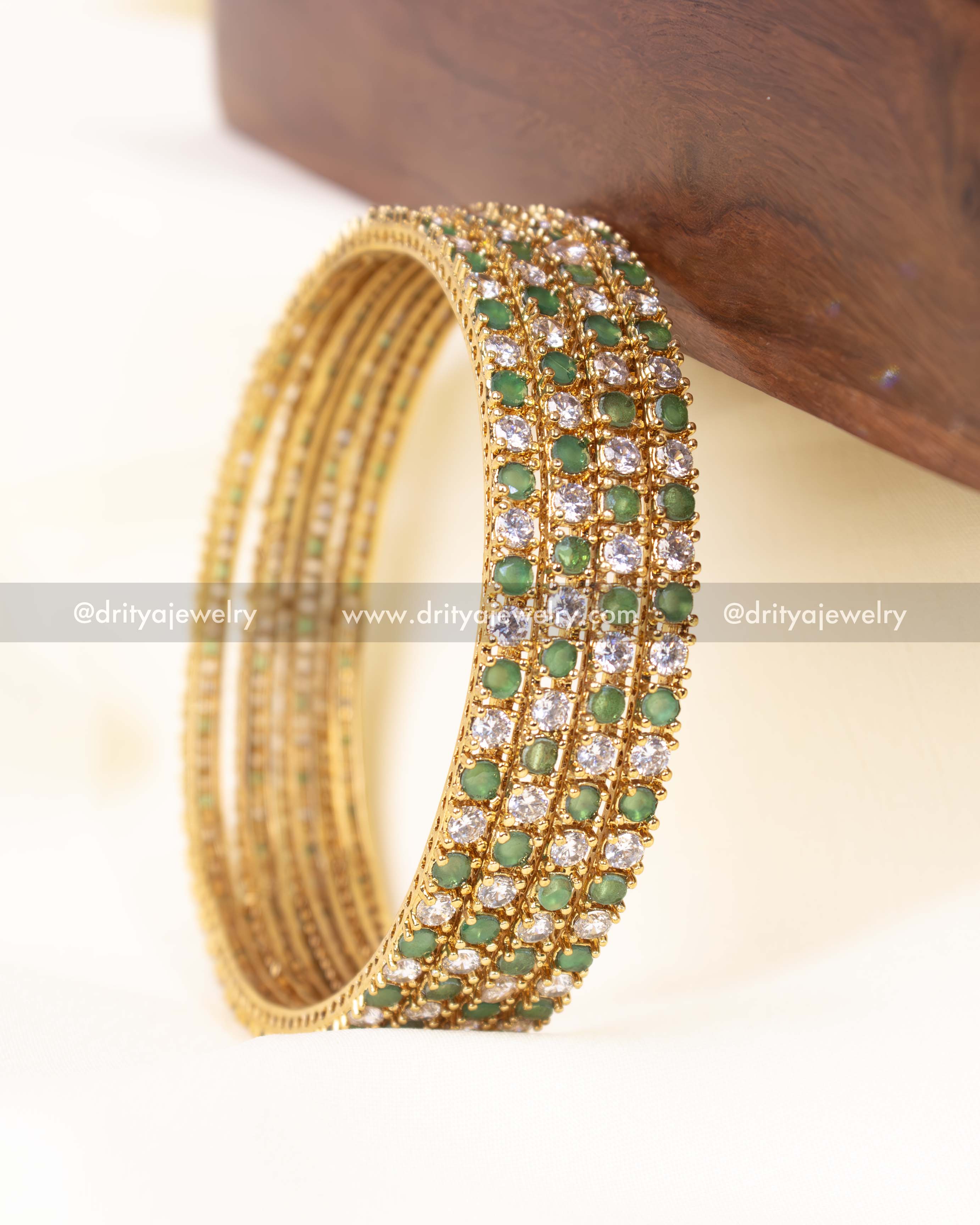 Luxurious CZ bangle set featuring green accents and gold plating, designed for weddings and festive occasions.