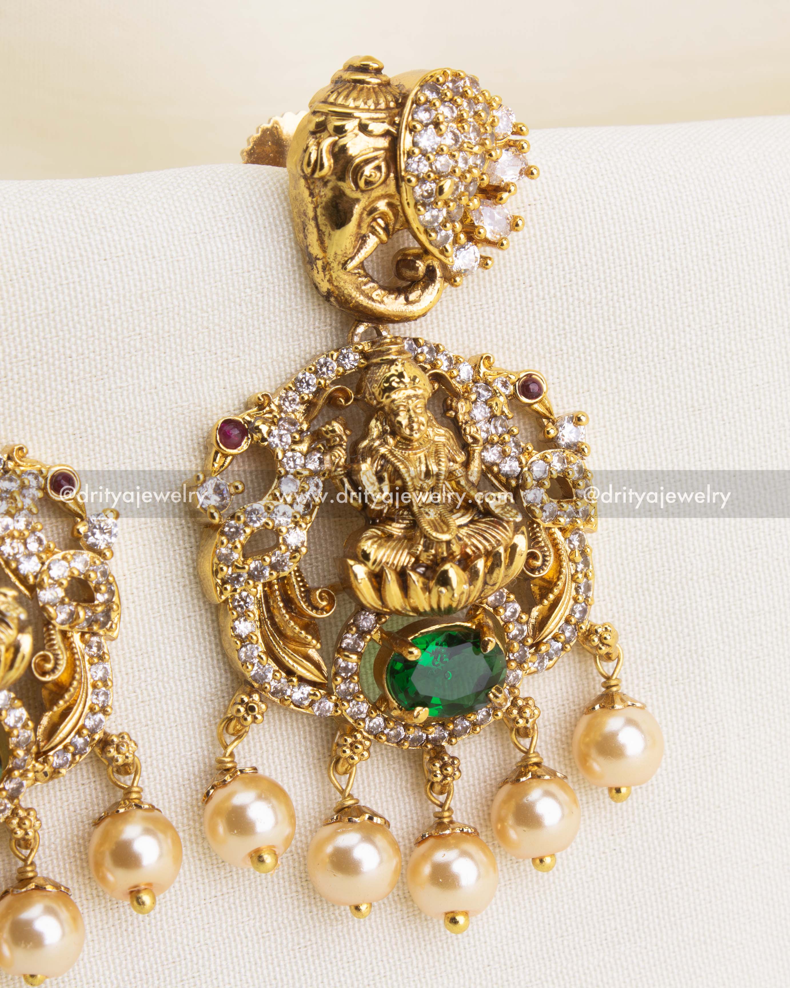 Detailed close-up of Lakshmi temple danglers with green oval stone and pearls.
