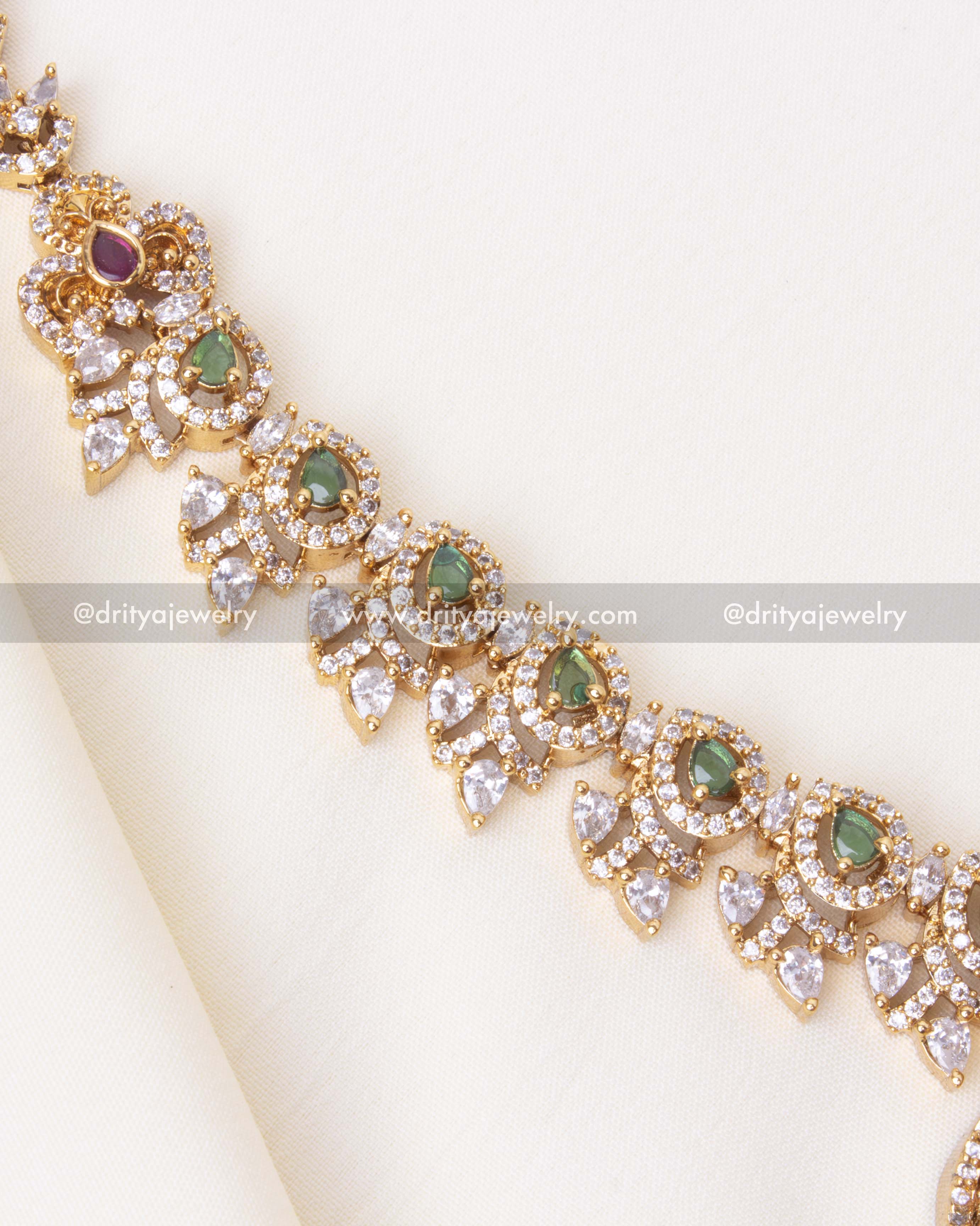 Detailed view of gold-plated Ram Parivar pendant with green stone embellishments and intricate craftsmanship.