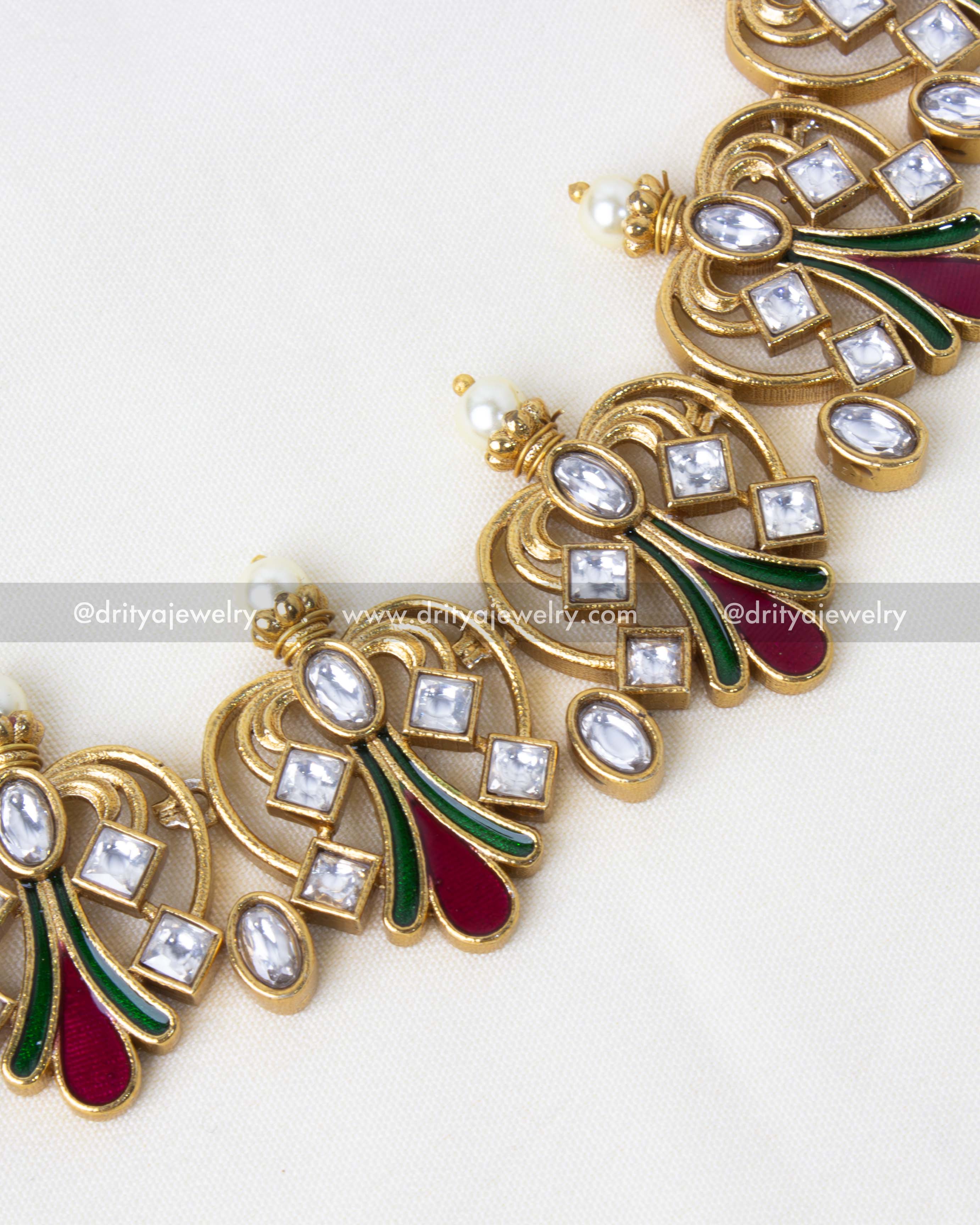 Detailed view of gold-plated necklace with peacock-inspired enamel motifs and Kundan embellishments.