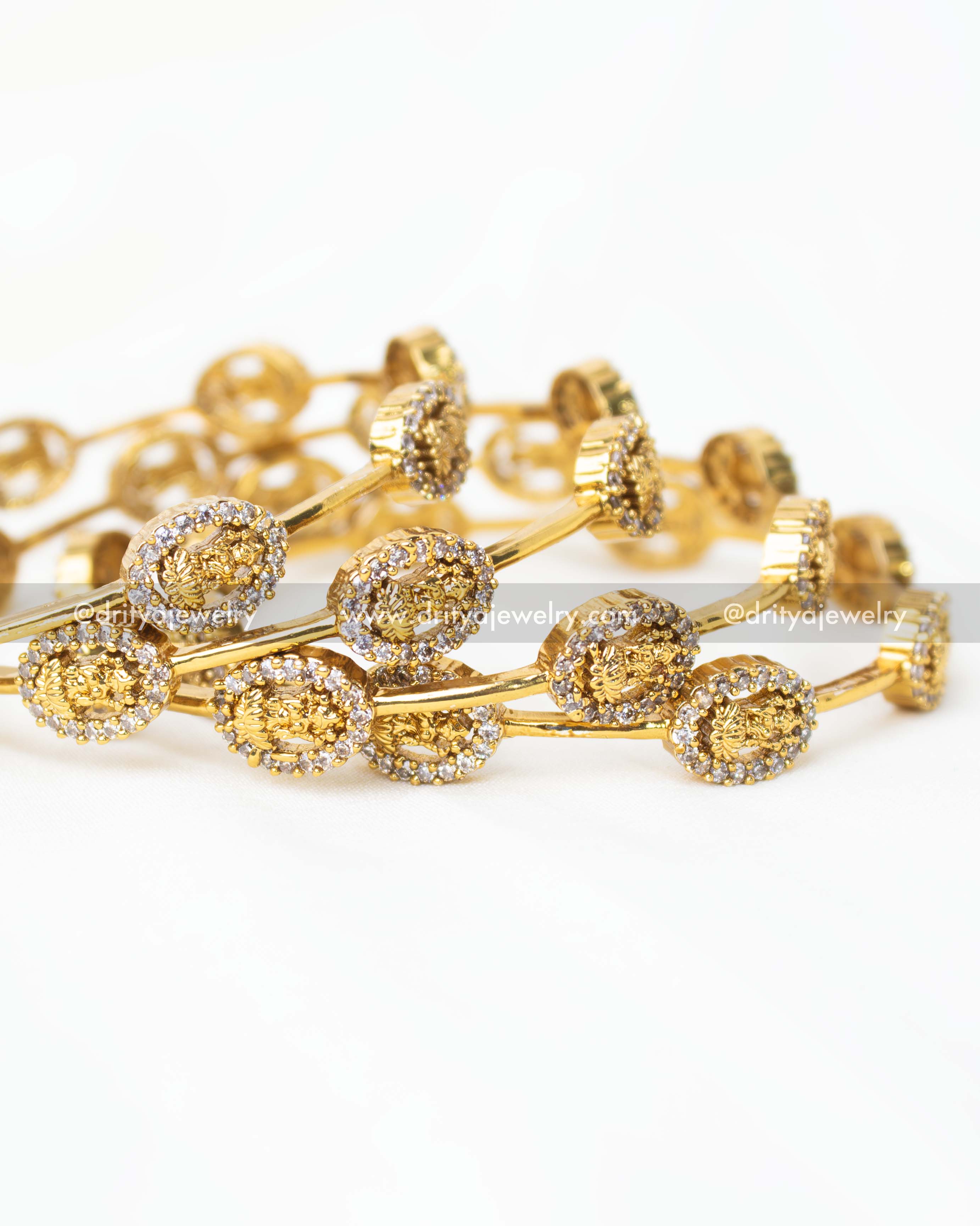 Detailed view of gold-plated Lakshmi temple bangles showcasing intricate design and sparkling stones.