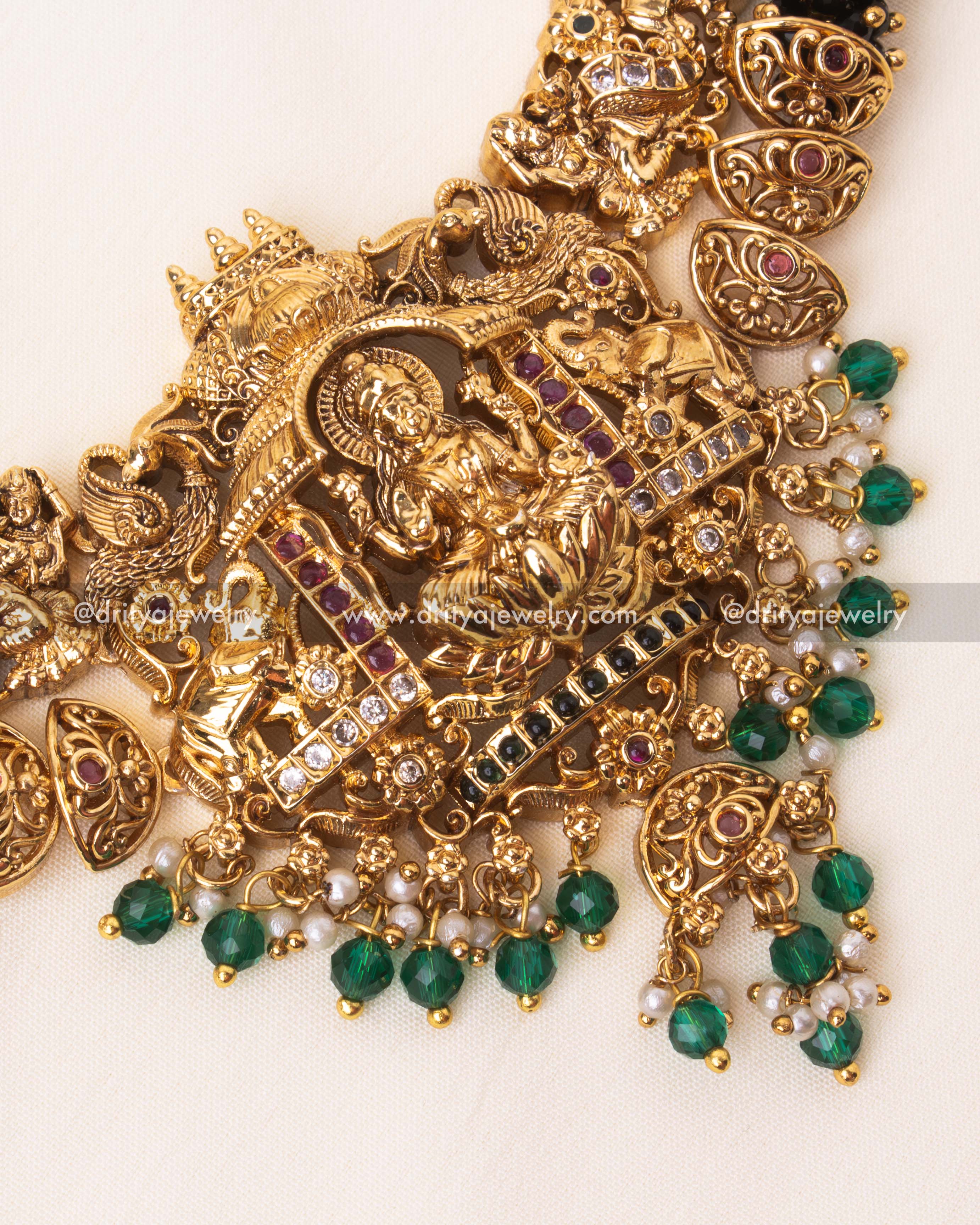 Detailed temple-inspired necklace with Nakshi engravings, green beads, and freshwater pearls.