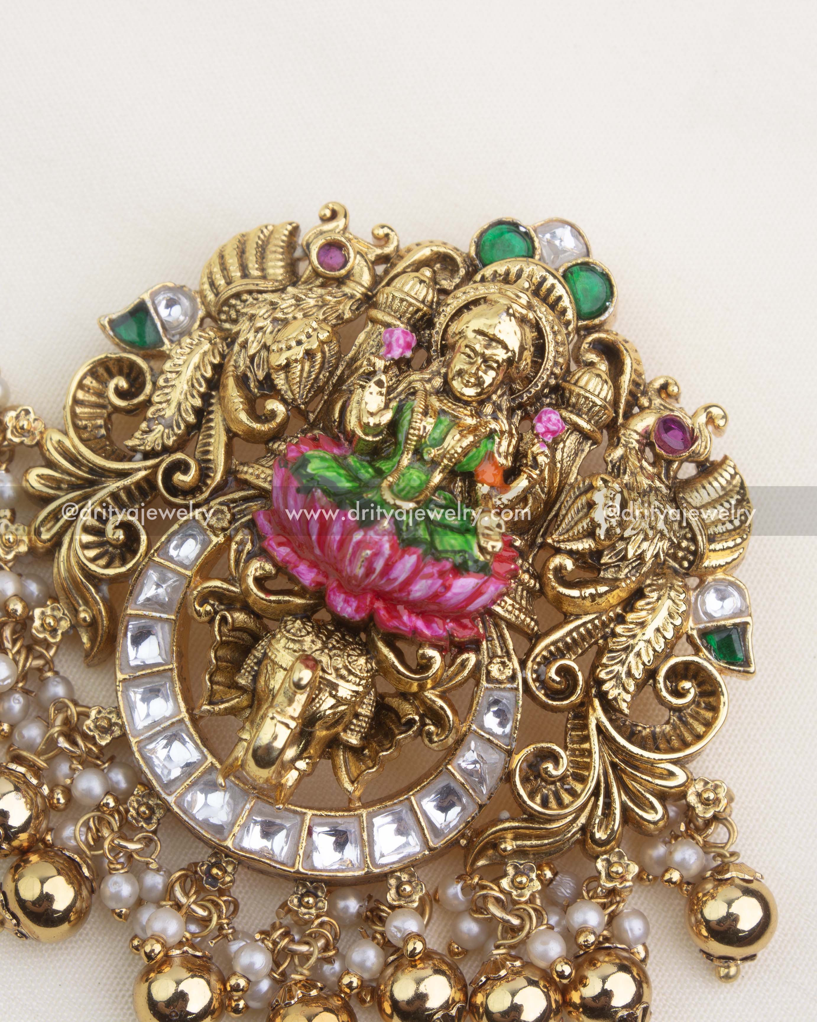 Detailed close-up of temple pendant with hand-painted meenakari work, peacock motifs, and antique gold nakshi carvings.
