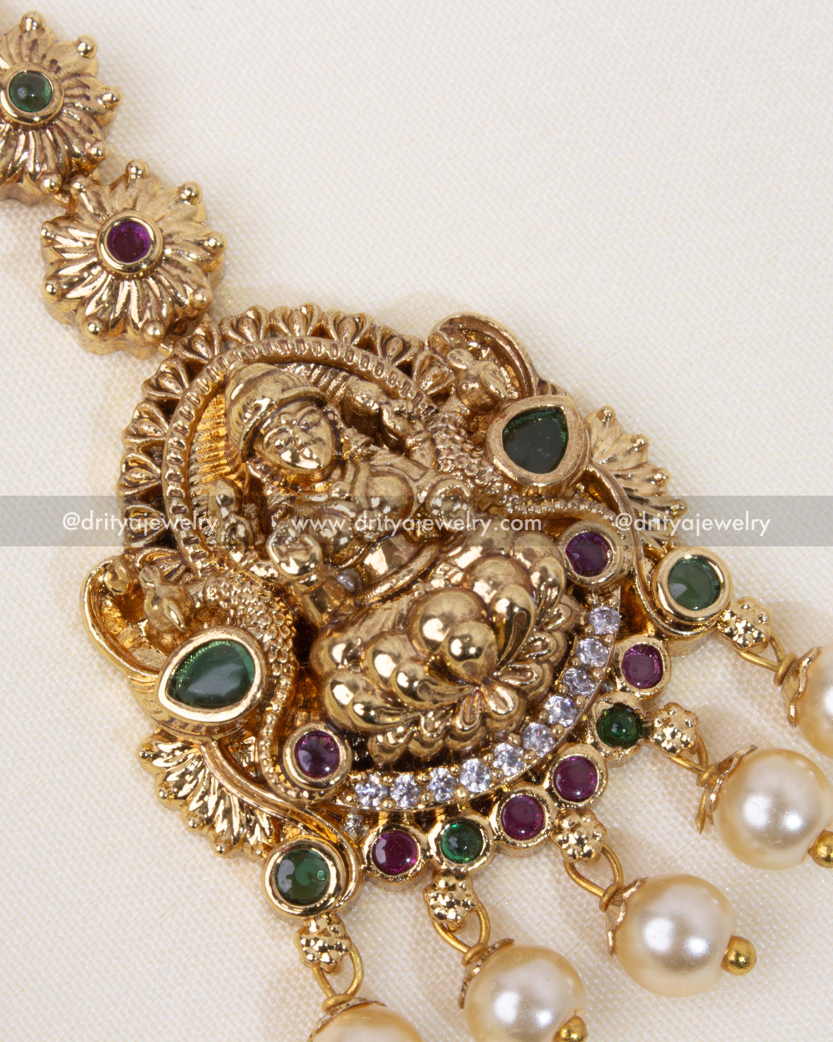 Detailed view of the Nakshi Maang Tikka, showcasing intricate motifs and pearl embellishments.