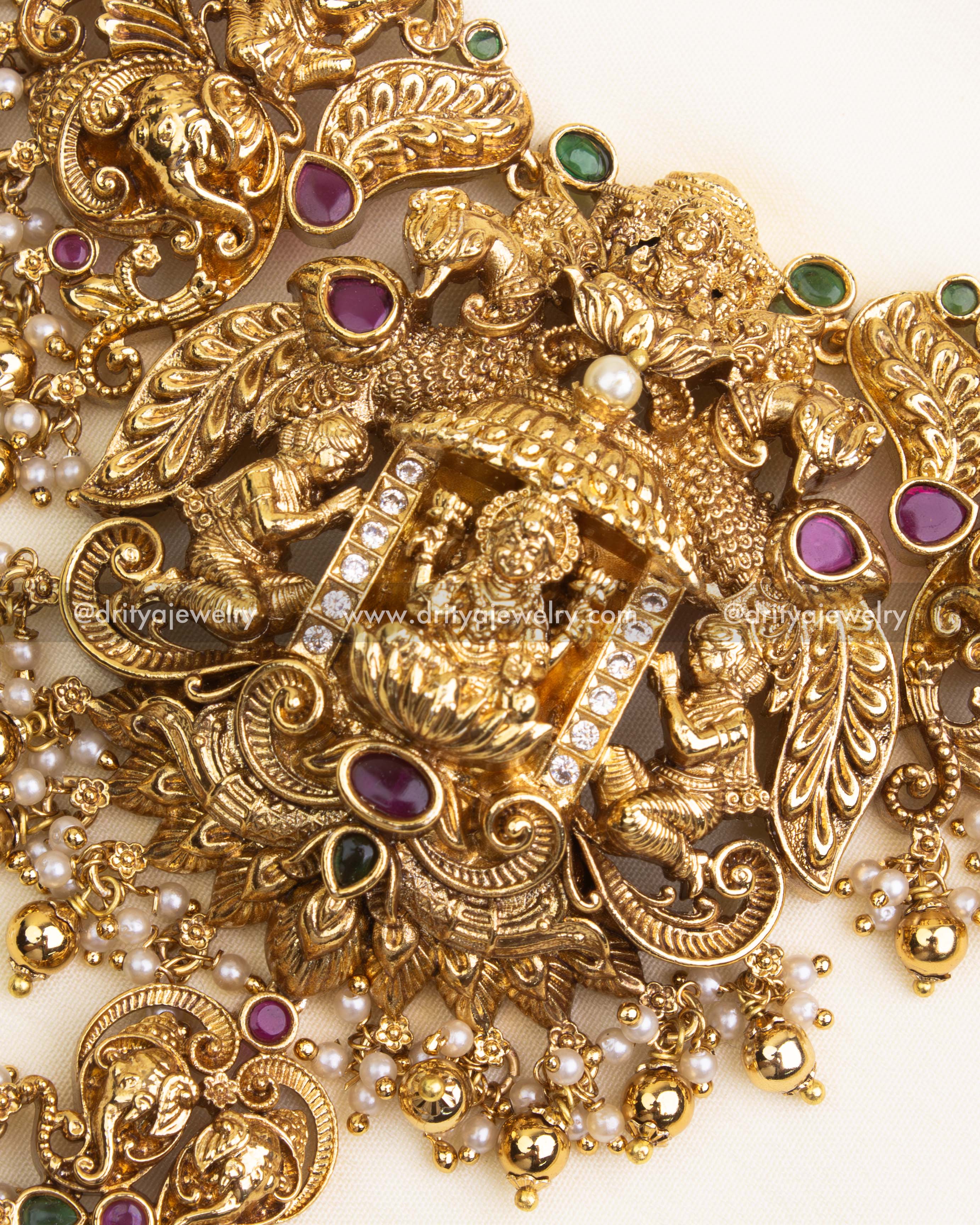 Detailed close-up of nakshi necklace featuring goddess idol, intricate carvings, and gemstone embellishments.
