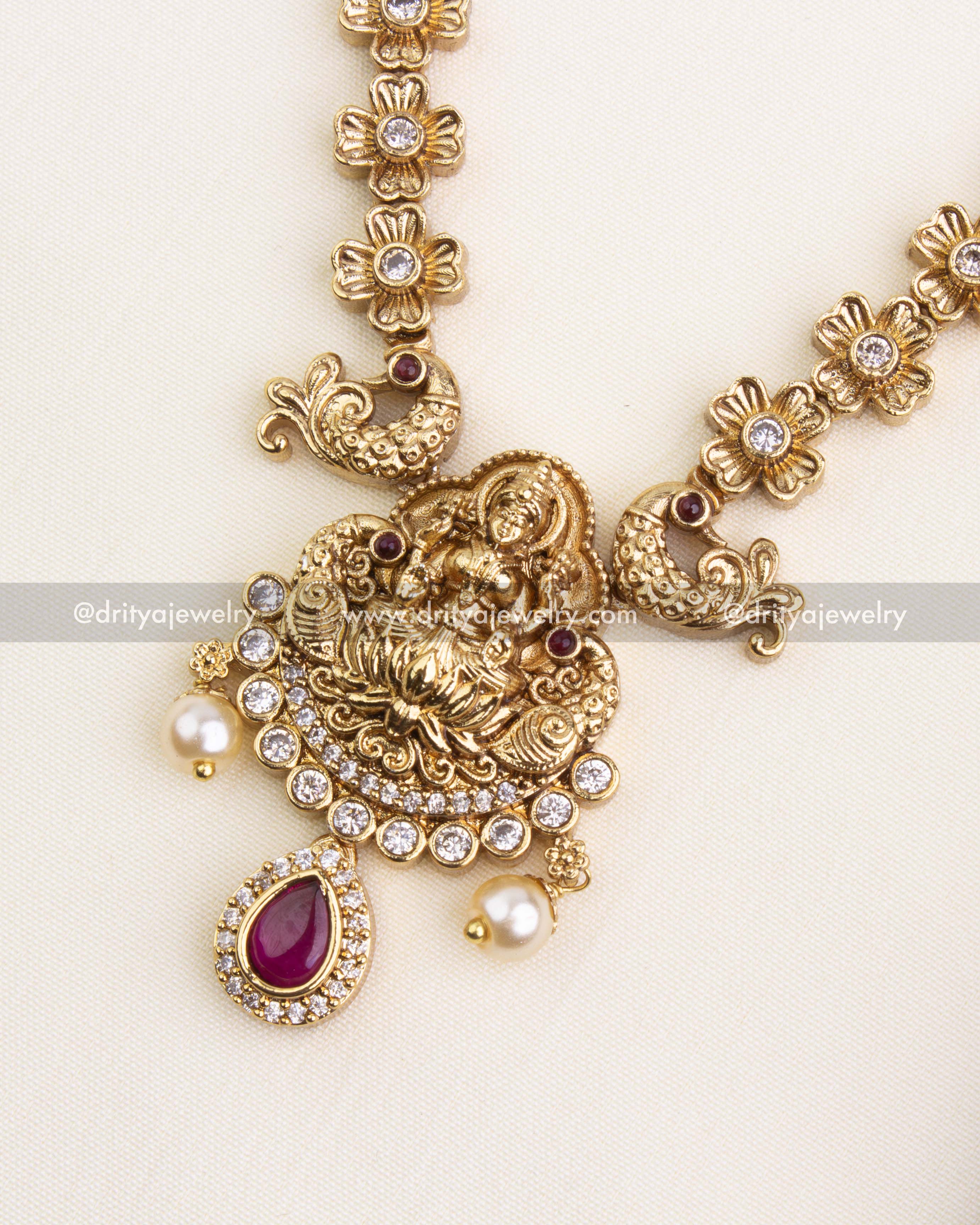 Detailed Lakshmi Devi motif pendant with antique finish and teardrop ruby stone.