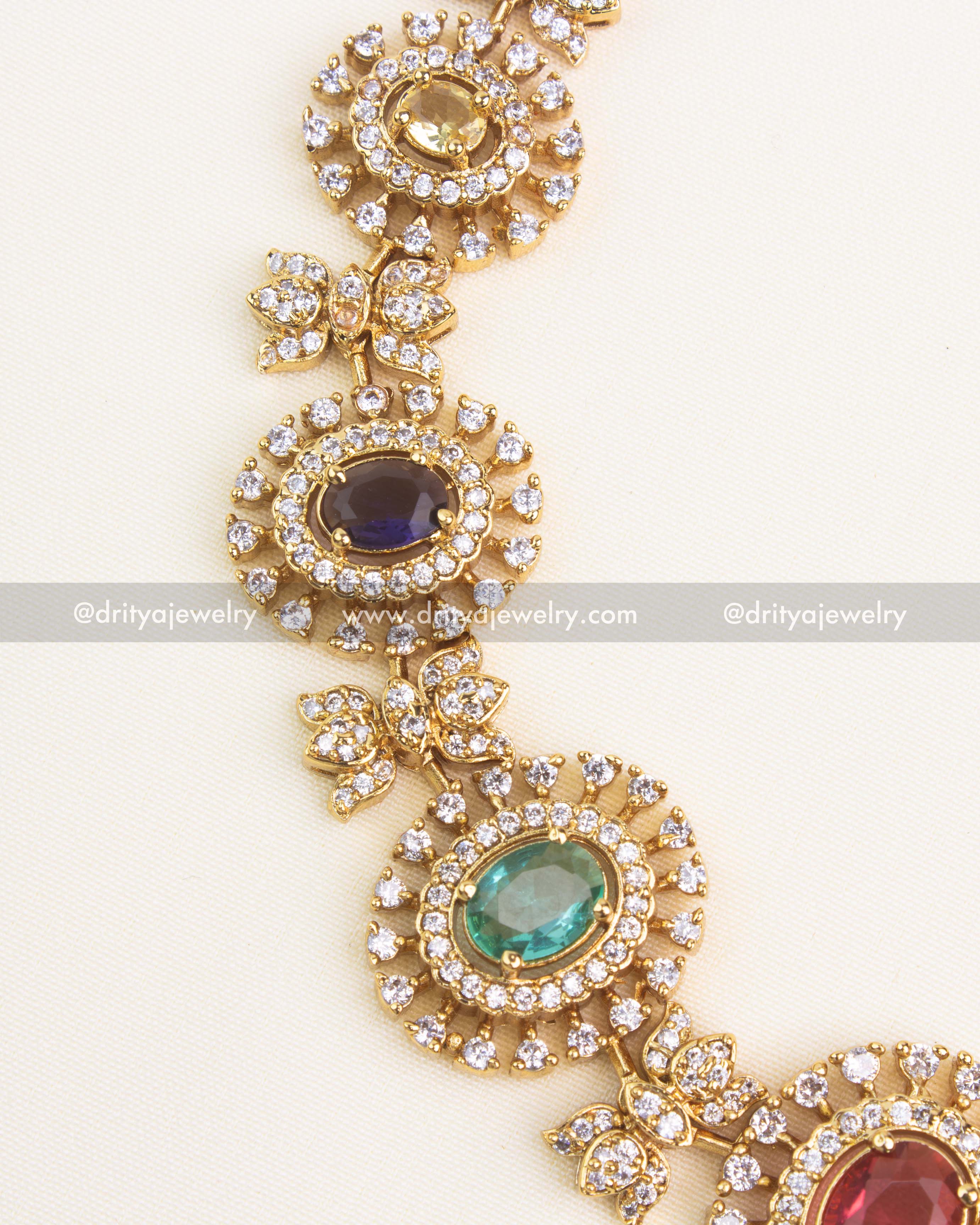 Detailed close-up of multicolor navaratna stones surrounded by CZ halo design in a short gold necklace.