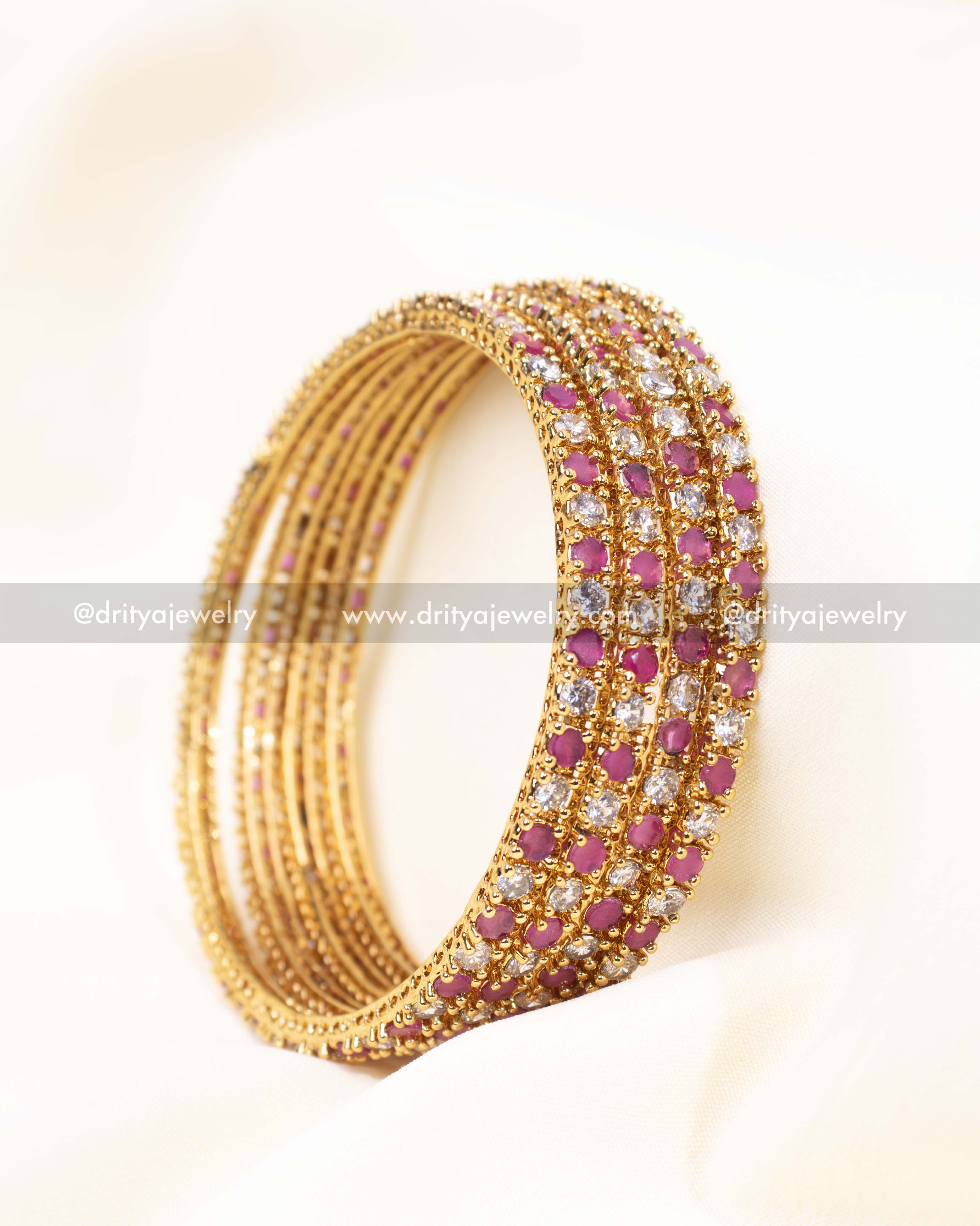 Detailed close-up of pink CZ bangles showcasing fine craftsmanship and a premium gold finish.