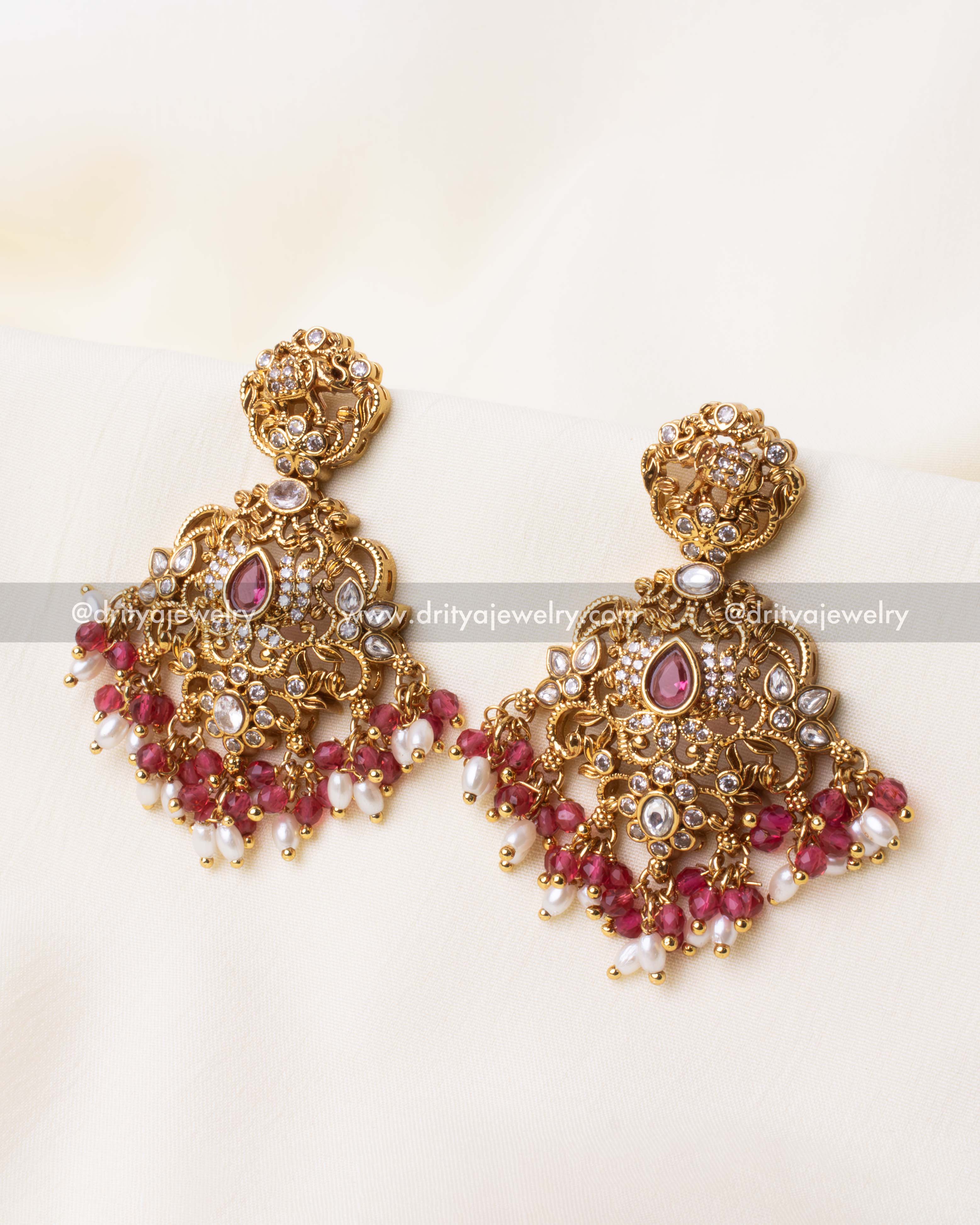 Handcrafted elephant motif dangler earrings with fine gold detailing, pink accents, and pearl drops.