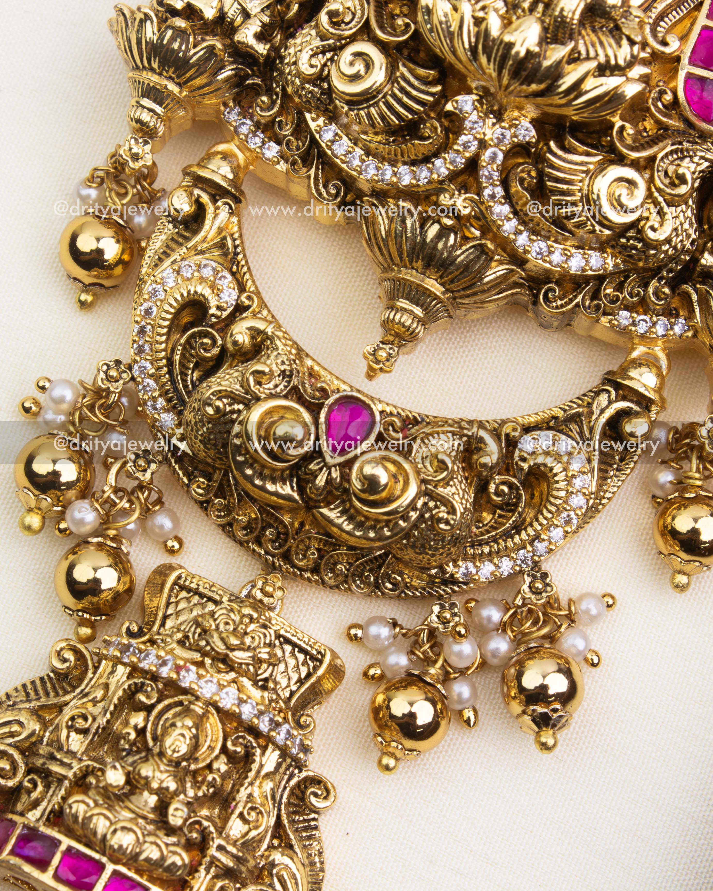 Intricate Nakshi detailing with pink stones on antique polished Jada Billa.