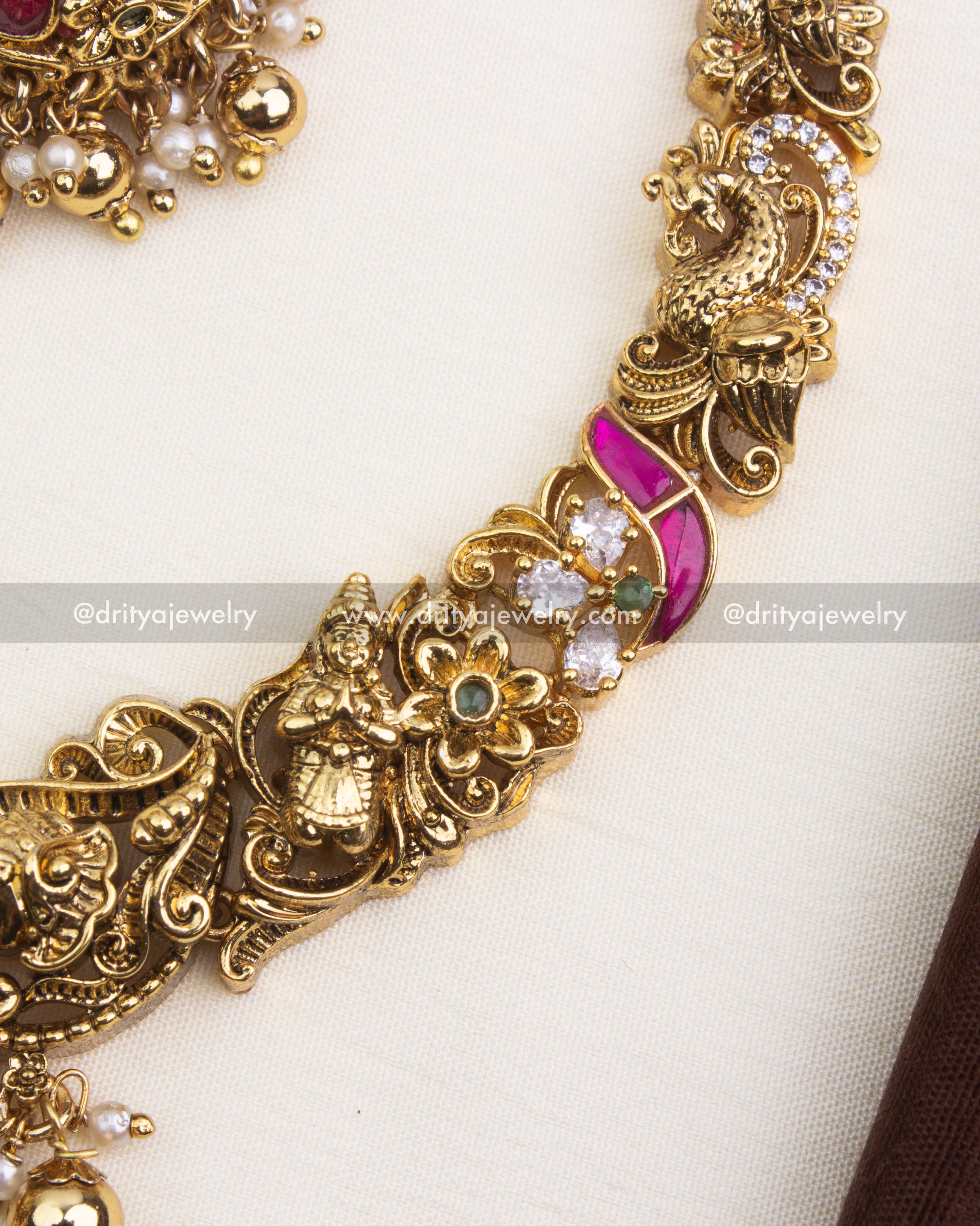 Detailed view of antique polished Ram Parivar necklace with pink and green kemp stones.