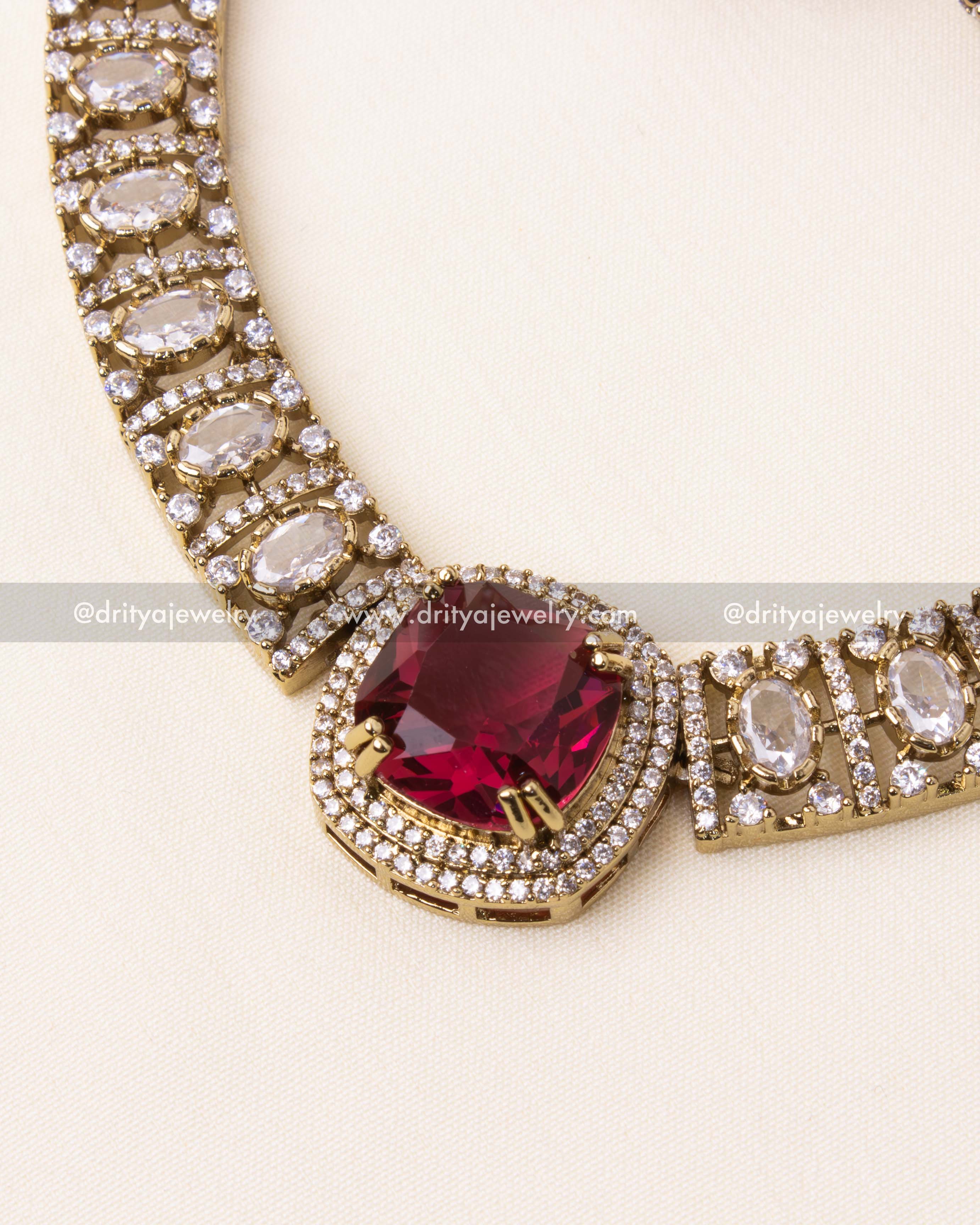 Intricate AD-studded necklace with a bold ruby-red gemstone centerpiece and premium gold plating.