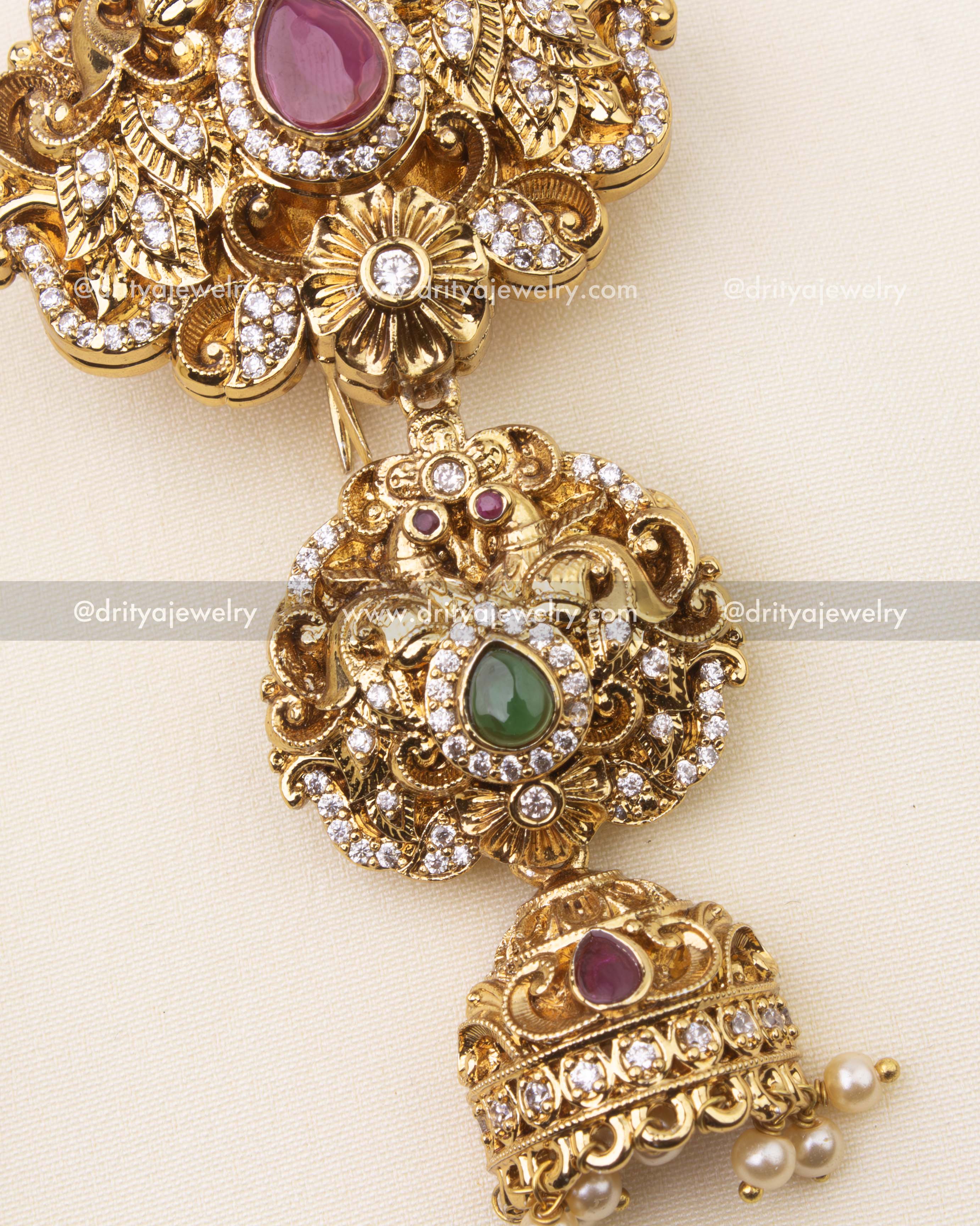 Detailed close-up of ruby stone Jada Billa with antique polish and floral carvings.