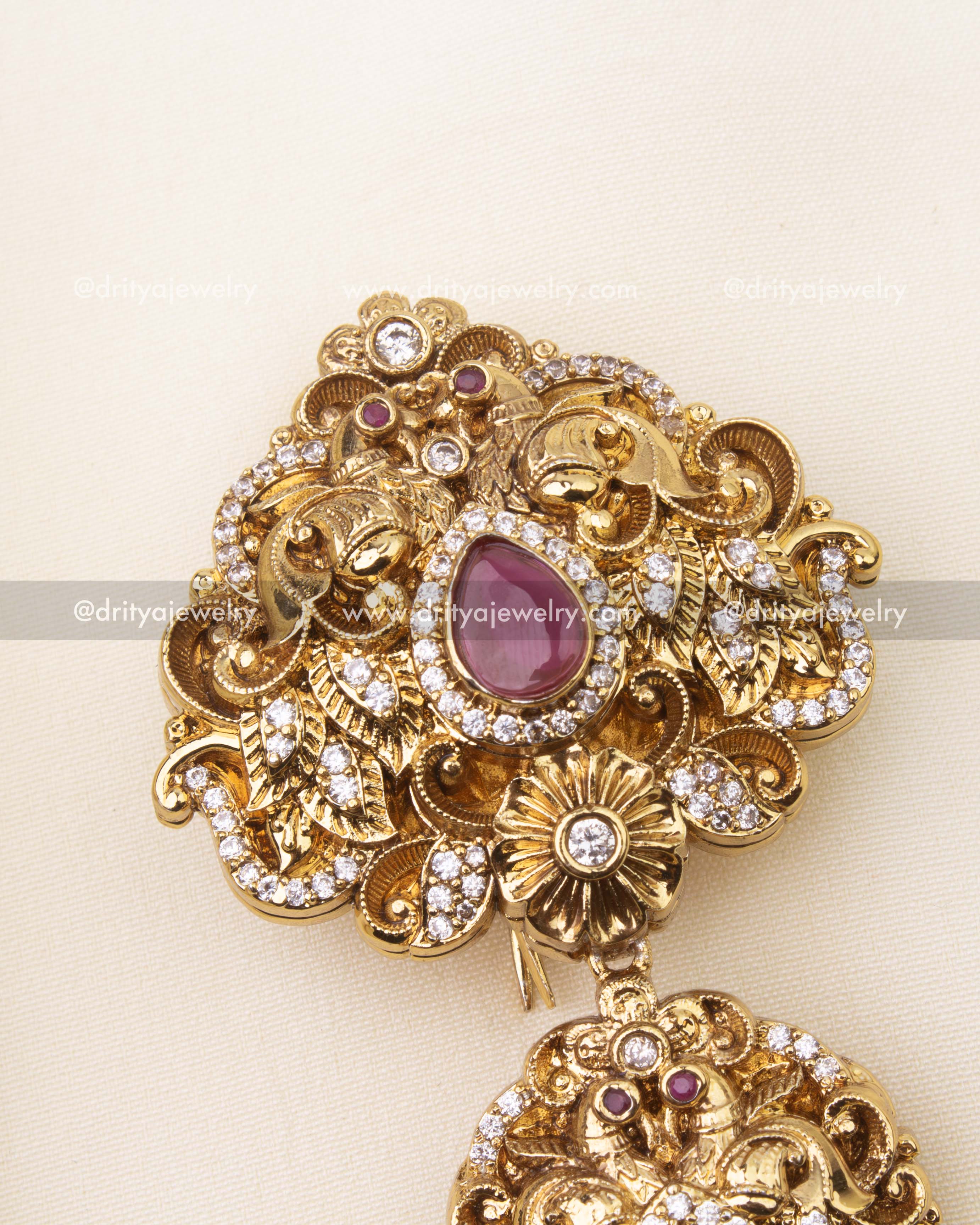 Detailed close-up of ruby stone Jada Billa with antique polish and floral carvings.