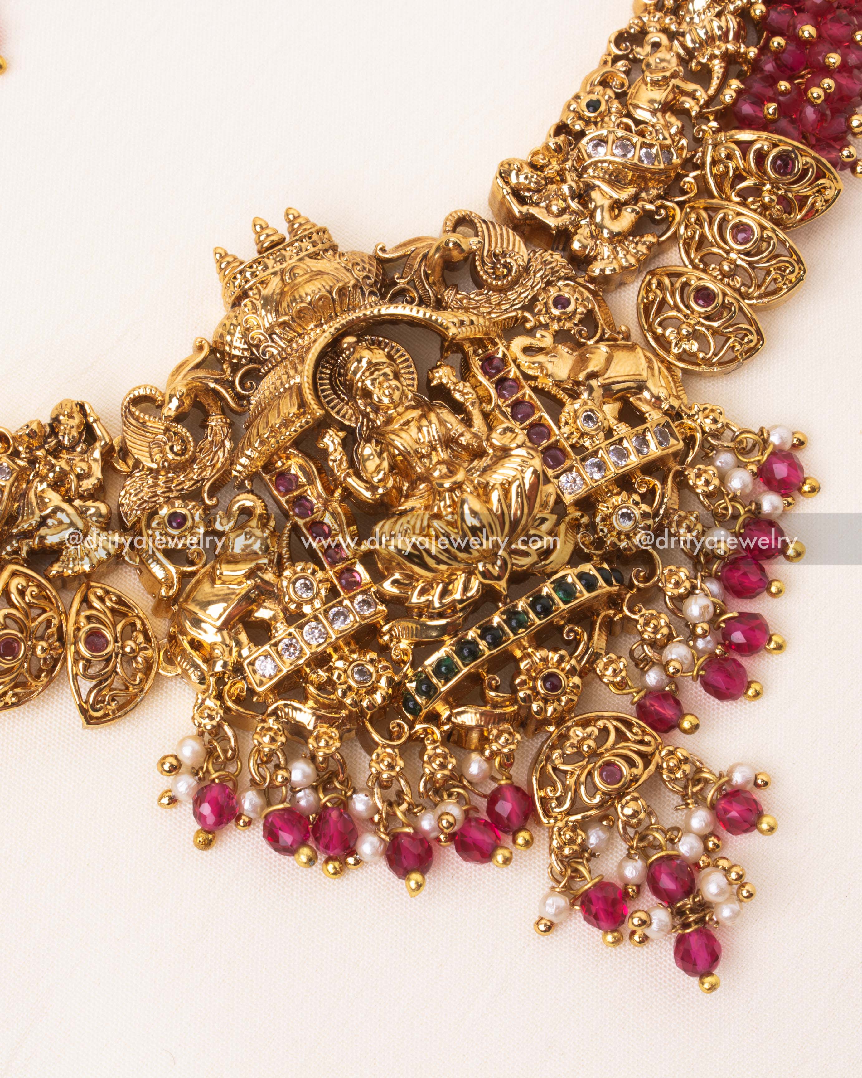 Detailed view of gold-plated temple necklace pendant with intricate Nakshi craftsmanship and ruby bead accents.