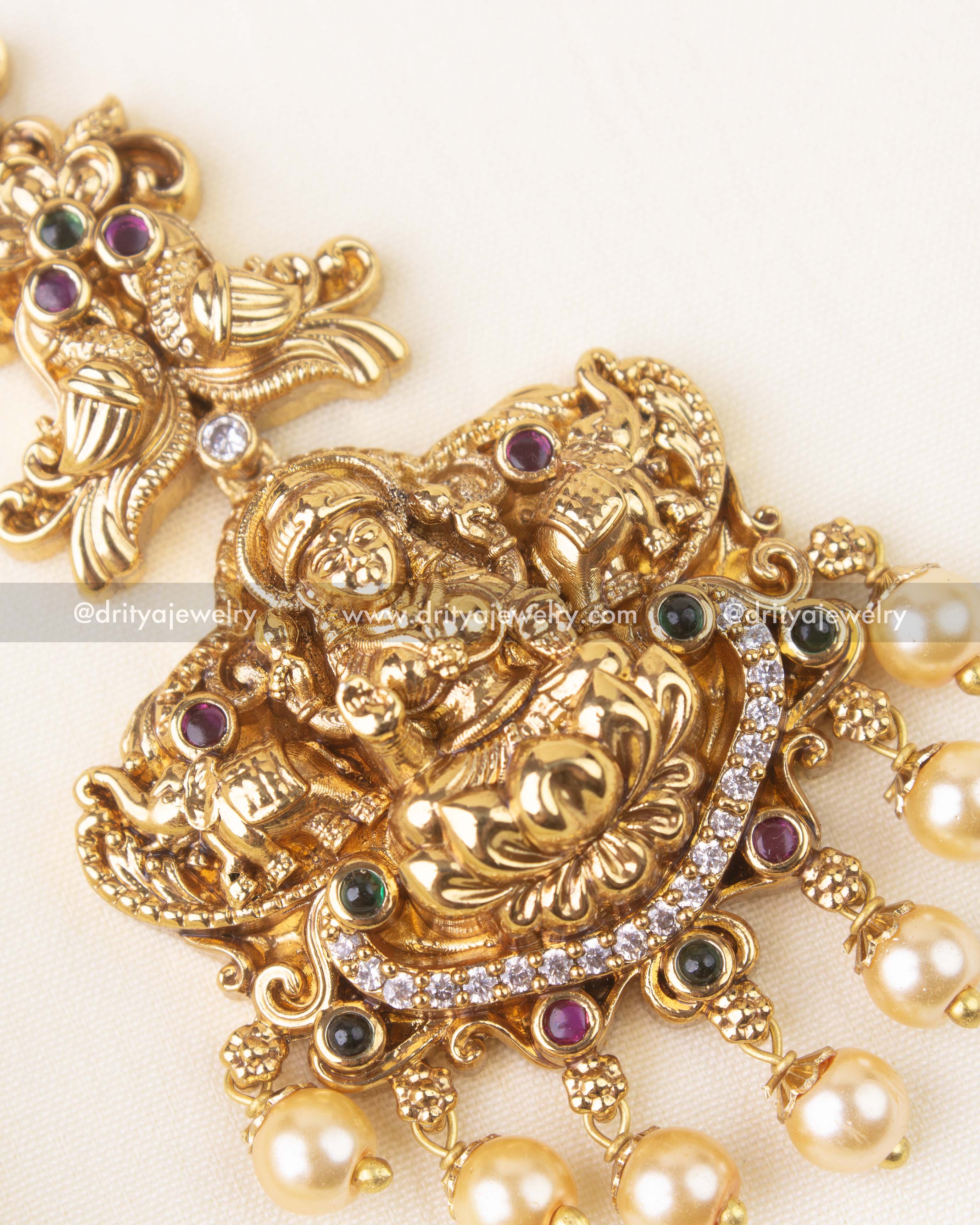Detailed view of temple maang tikka with CZ stones, colored gems, and peacock detailing