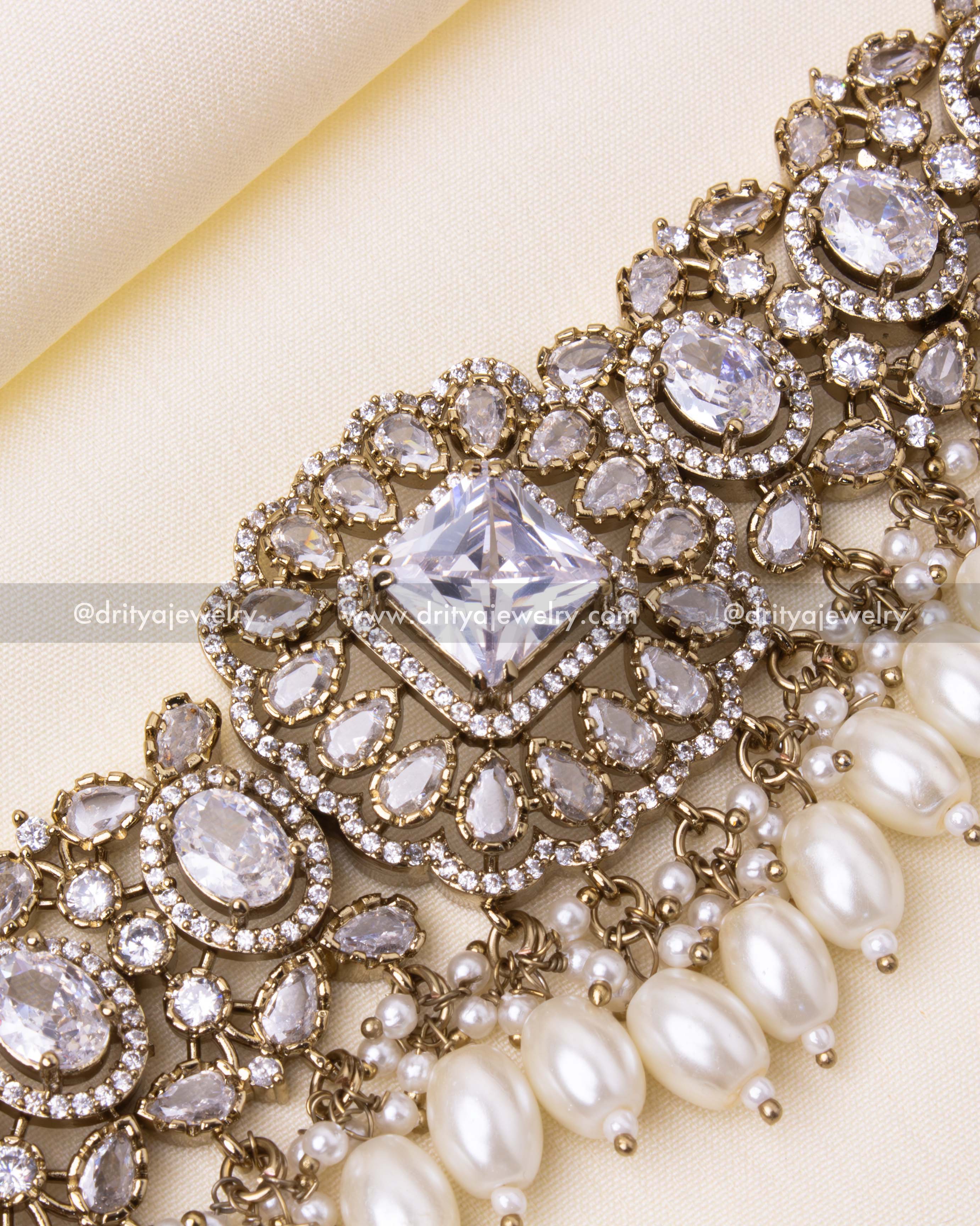 Detailed view of the central square-cut CZ stone surrounded by floral motifs and pearl drops.